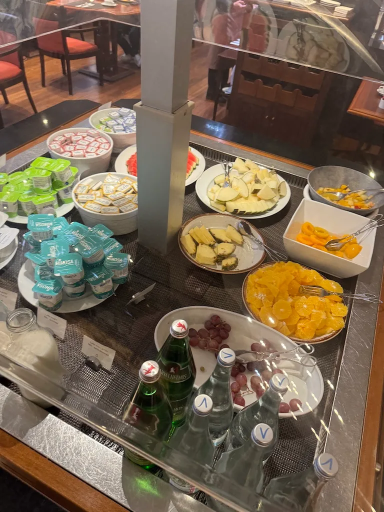 Frühstückstablett mit Obst, Käse und Getränken auf einem Buffet