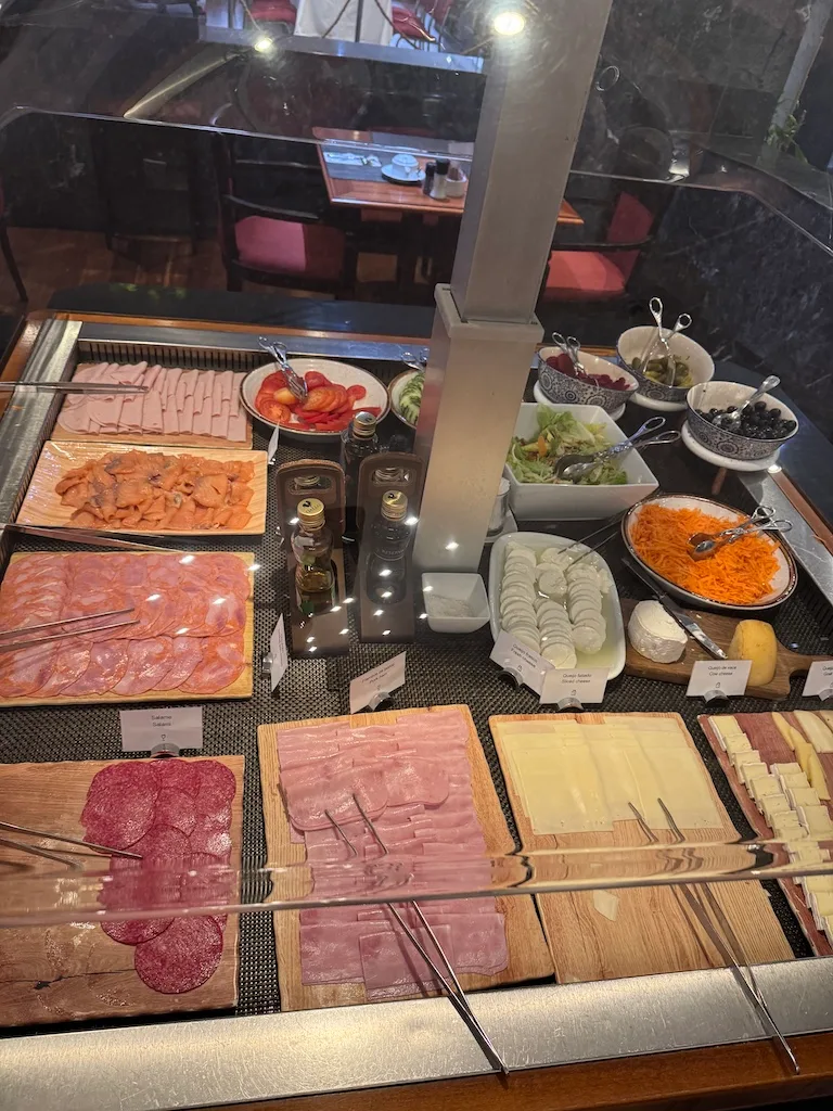 Frühstücksbuffet mit verschiedenen Fleischsorten, Salaten und Beeren