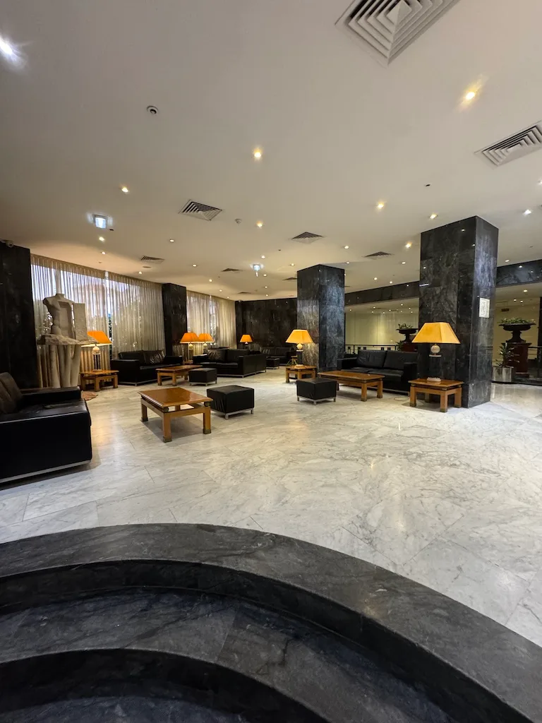 Hotellobby mit schwarzen Sesseln und Couchtischen