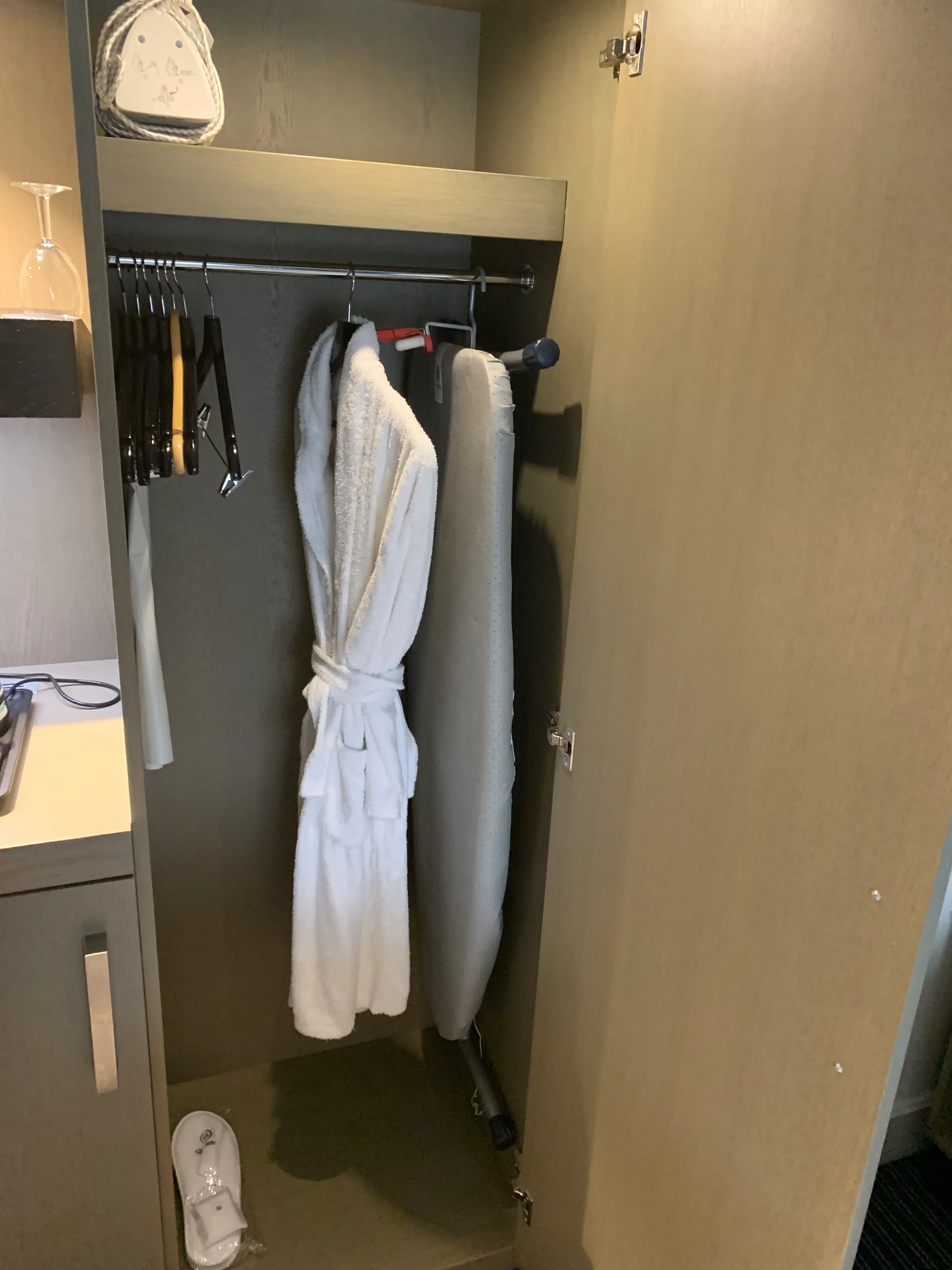 Schrank mit Bademantel und Bügeleisen im Hotelzimmer