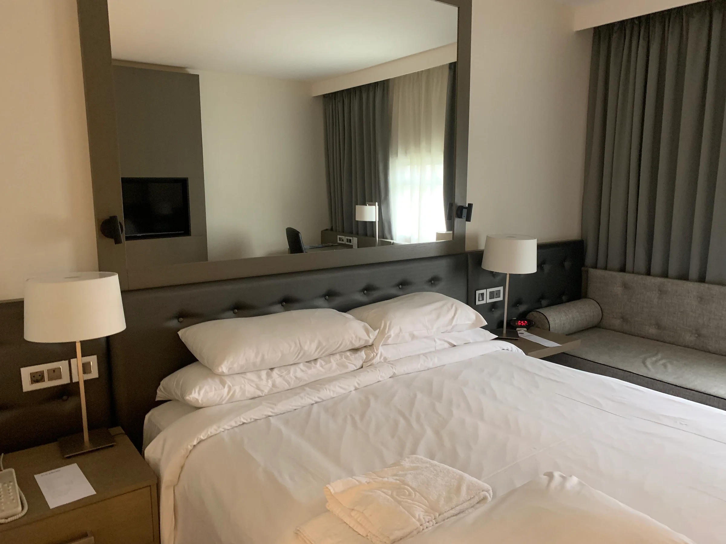 Hotelzimmer mit Doppelbett und grauem Kopfteil