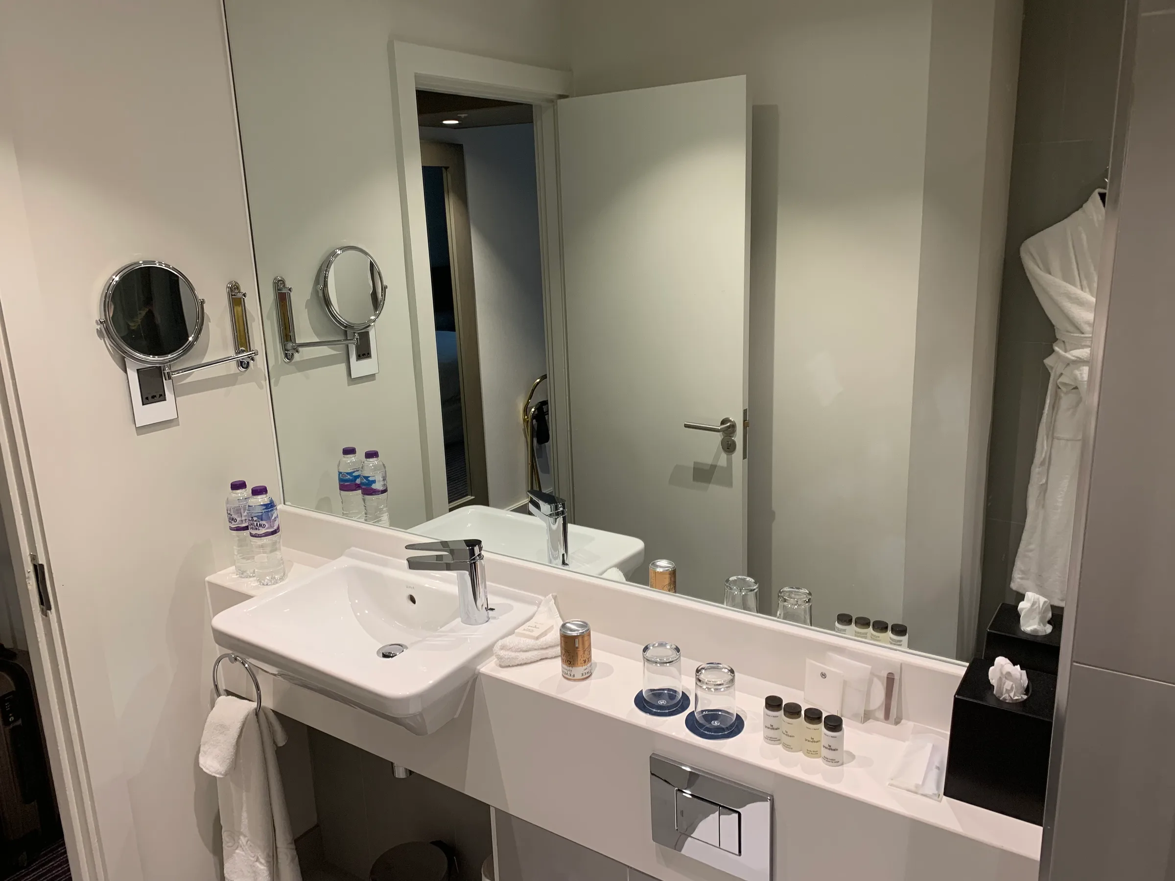 Hotelbadezimmer mit Waschbecken, Spiegeln und Handtüchern