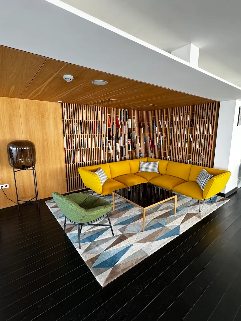 Gelbes Sofa im modernen Wohnraum mit Holzregal und Teppich
