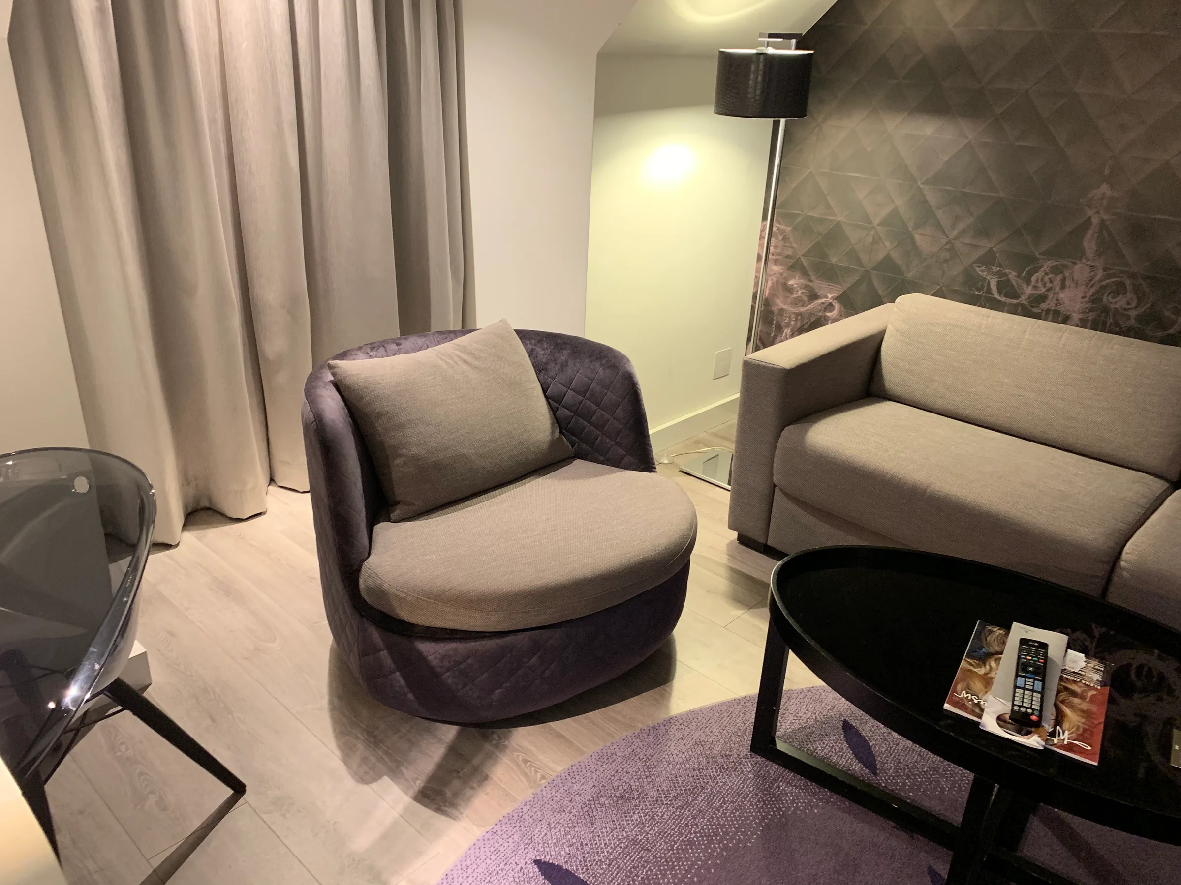 Graues Sessel mit Kissen in einem modernen Hotelzimmer