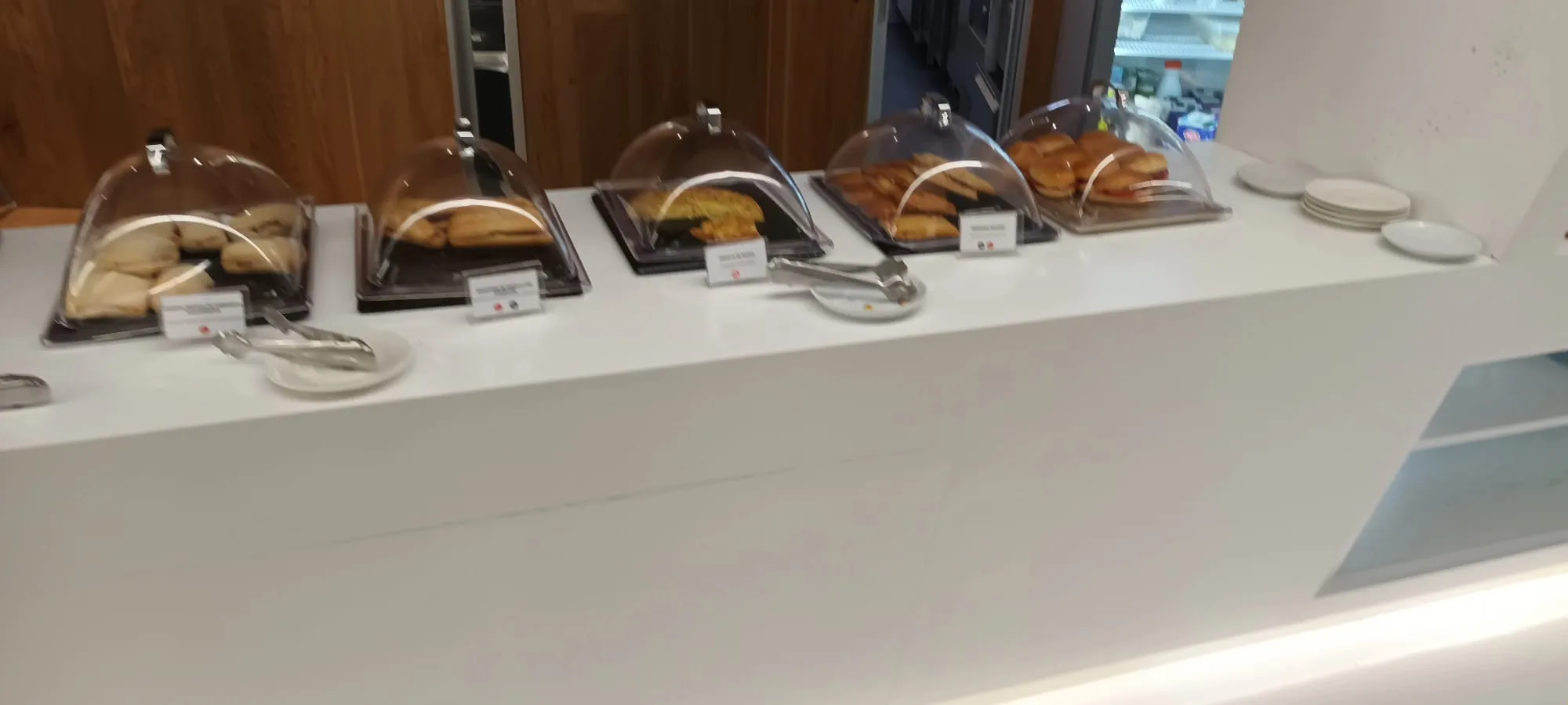 Buffet mit verschiedenen Gebäcksorten unter Glasbehältern