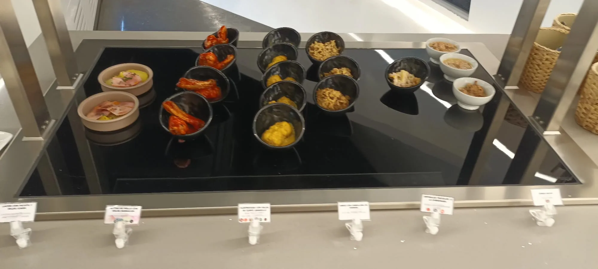 Verschiedene Snacks in Schalen auf einem schwarzen Tisch