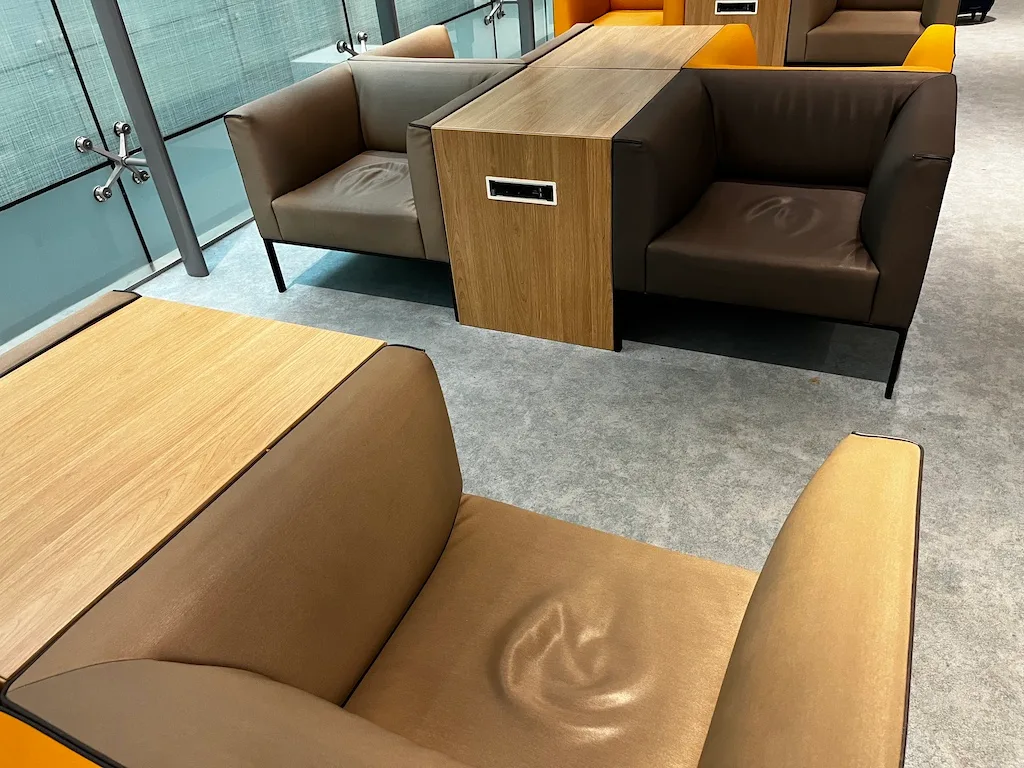 VIP-Sitzbereich mit Ledersofas und Holztisch im Flughafensalon