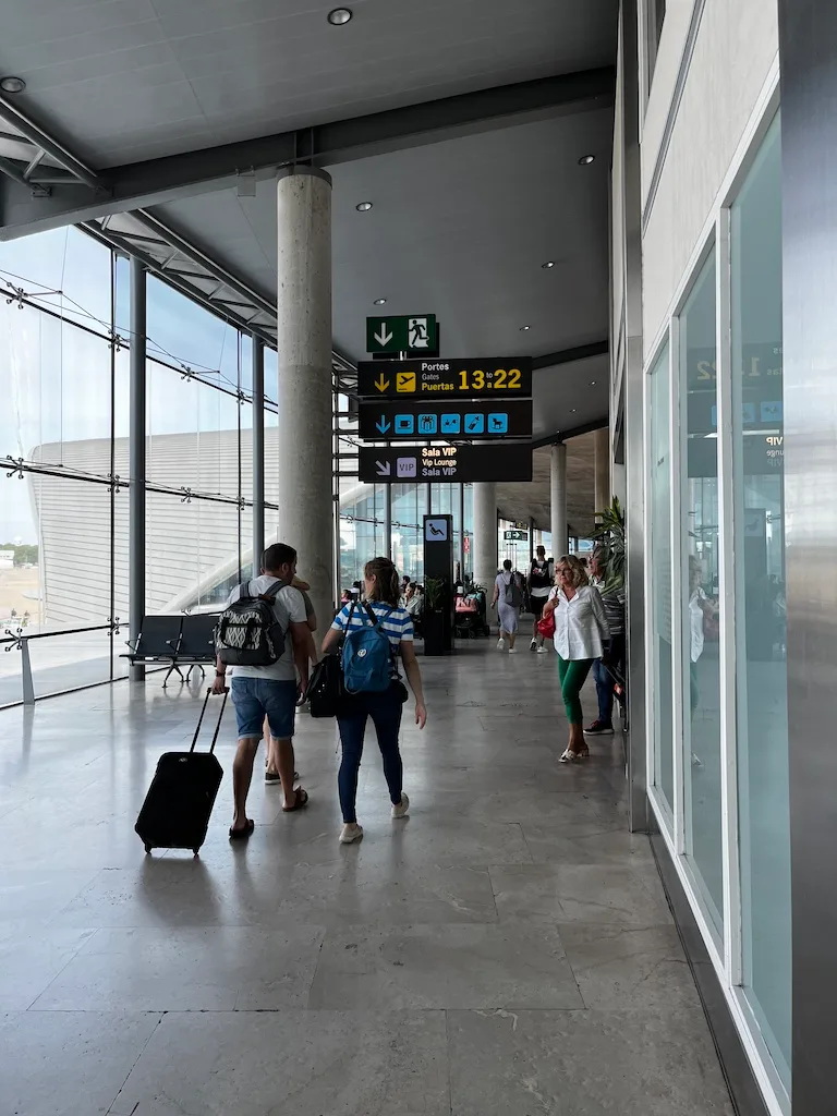 Flughafenterminal mit Passagieren und Schildern für Gates