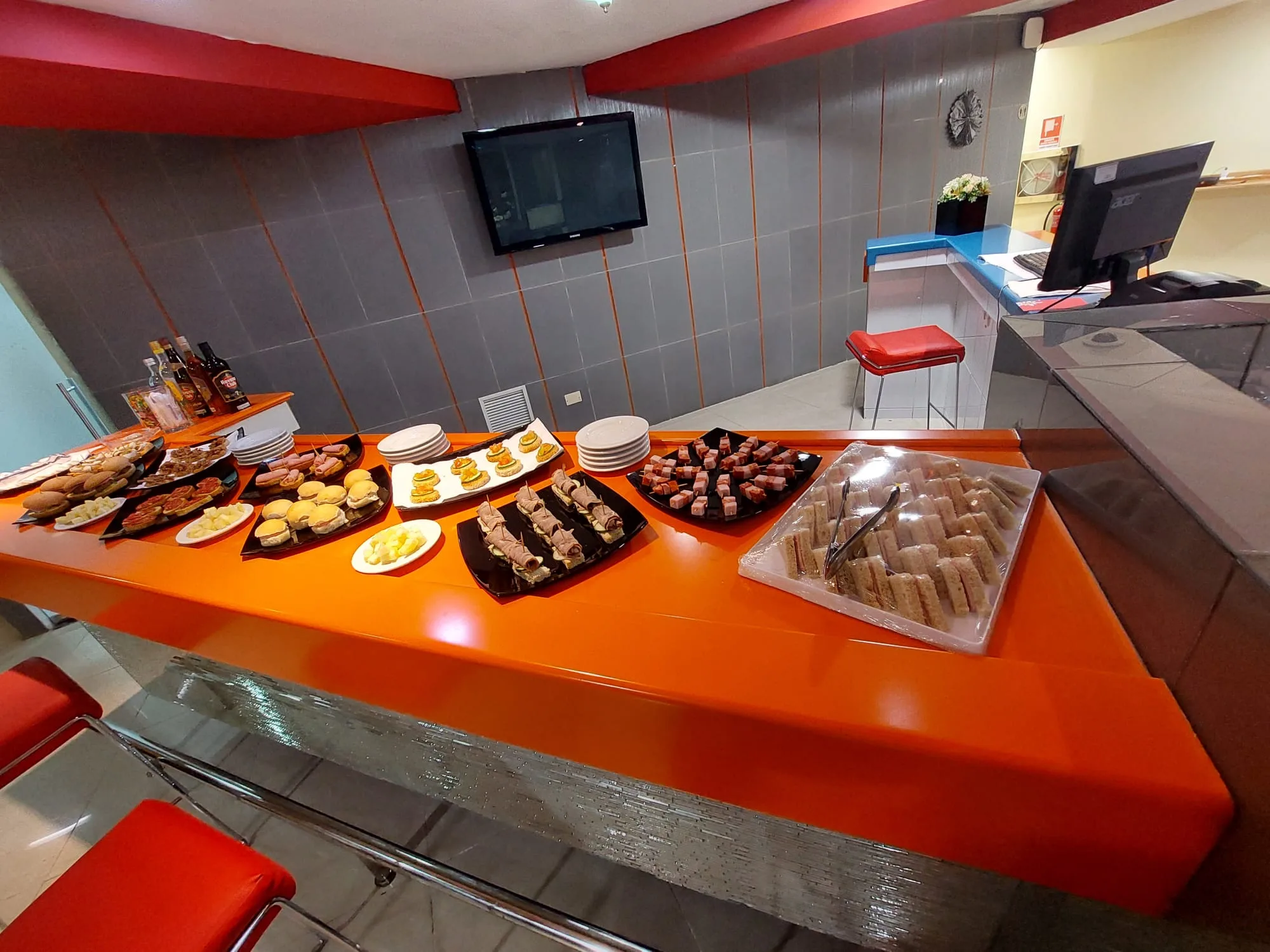Lounge mit verschiedenen Snacks auf orangefarbener Theke