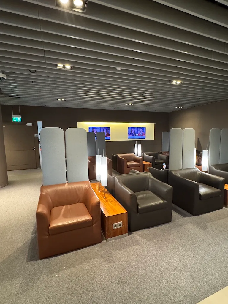 Lounge mit Sesseln und Tischen in Grautönen