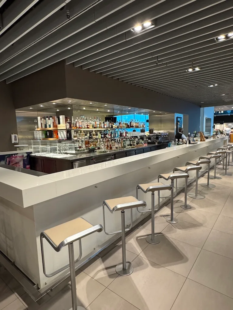 Bar mit Stühlen und Getränkeauswahl im Loungebereich