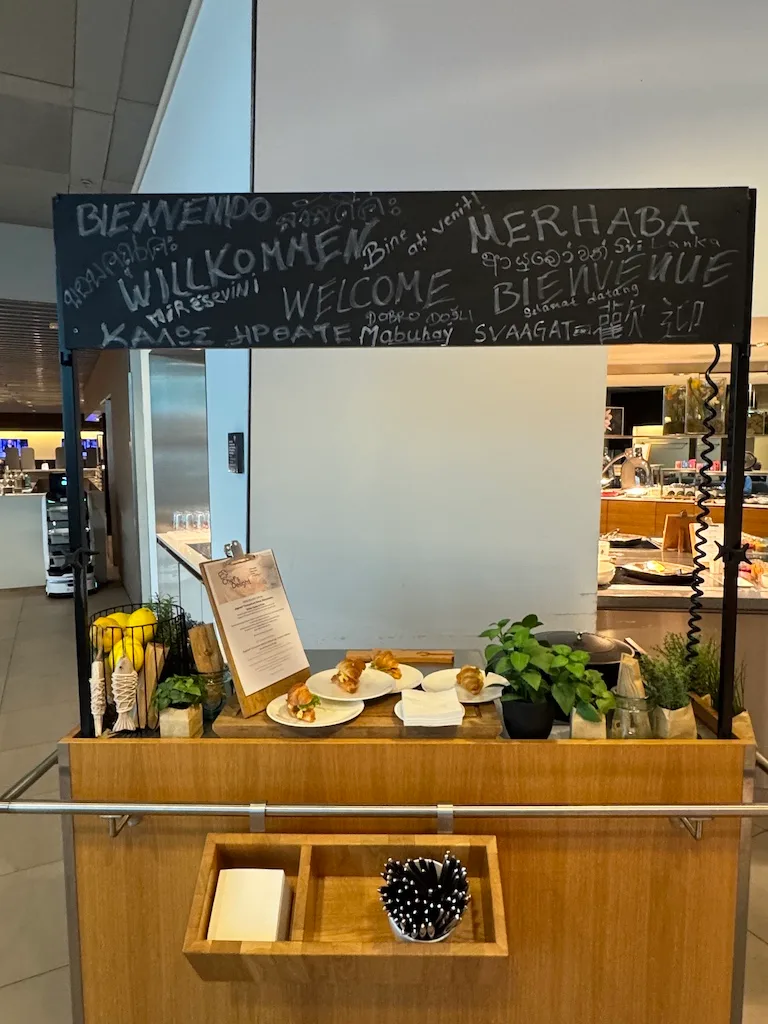 Willkommensschild mit verschiedenen Sprachen in einem Flughafenlounge