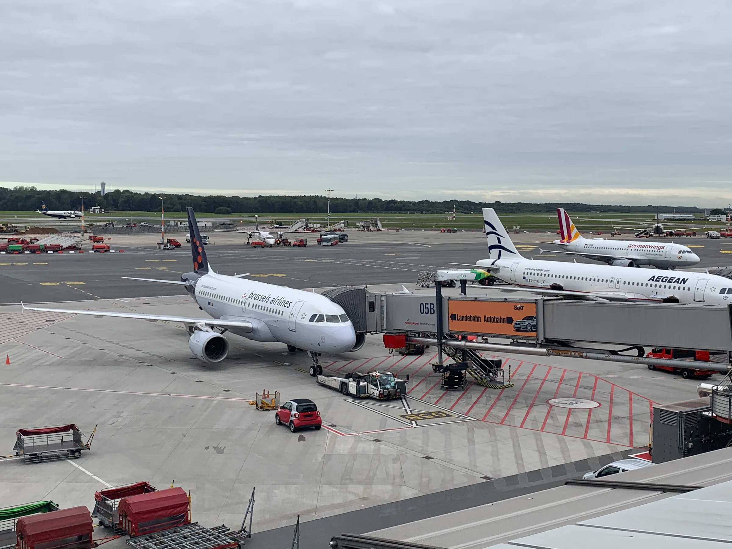 Flugzeug am Flughafensteig mit Rolltreppe und anderen Maschinen im Hintergrund