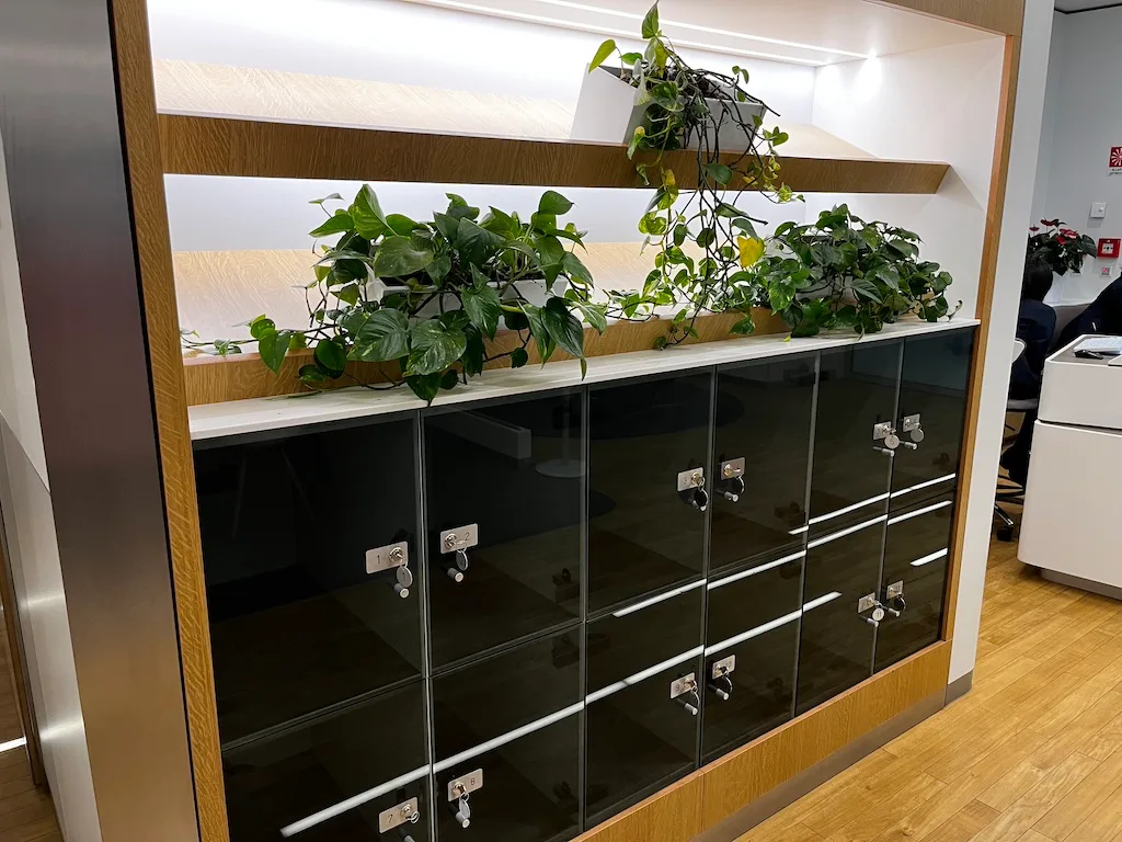 Glasvitrine mit Schließfächern und Pflanzen im Hintergrund
