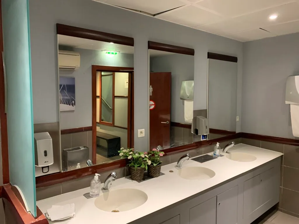Flaschenregal mit Olivenölflaschen und Gläsern im Flughafenlounge