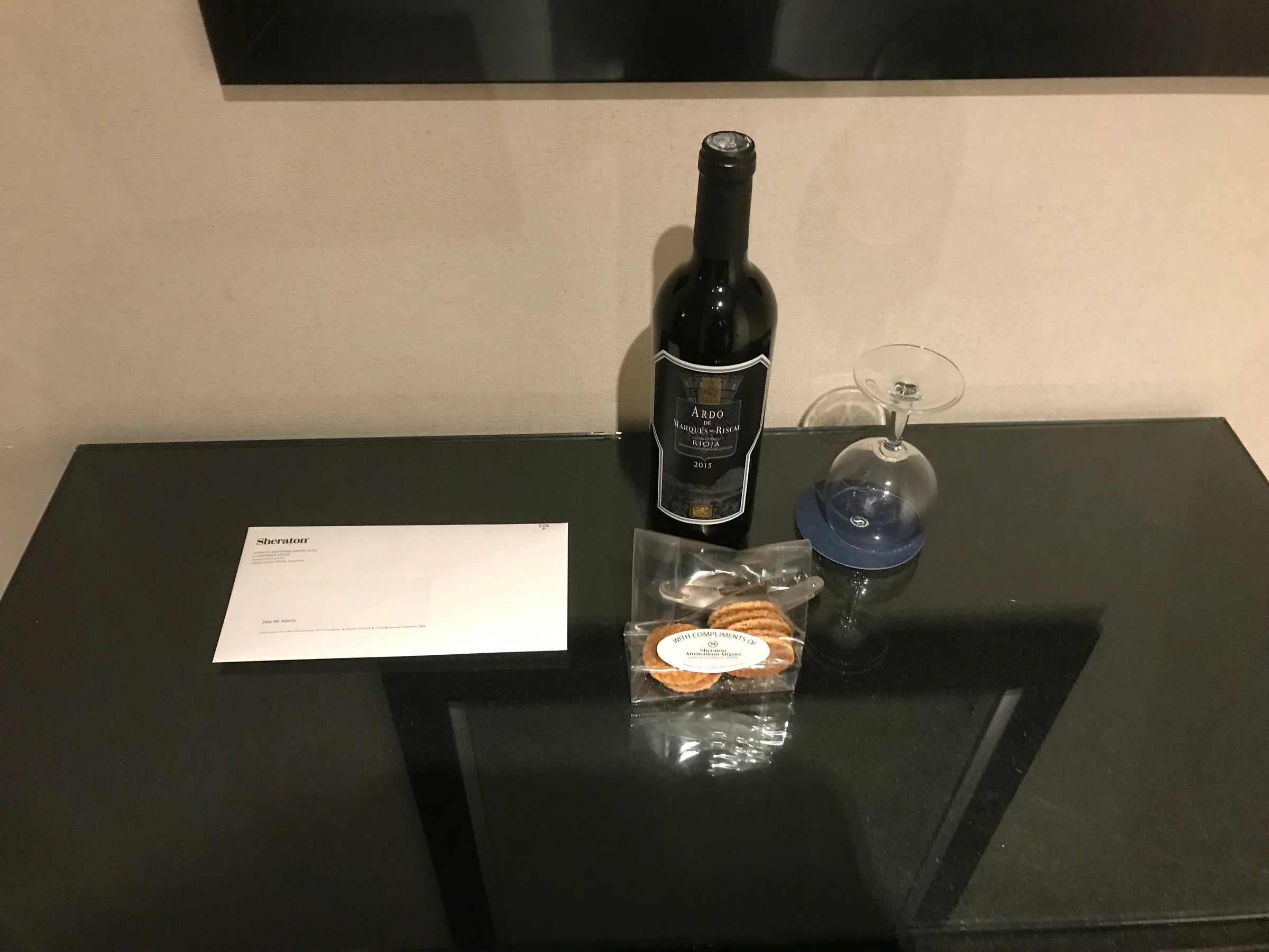 Hotelzimmerecke mit Weinflasche, Gläsern und Snacks