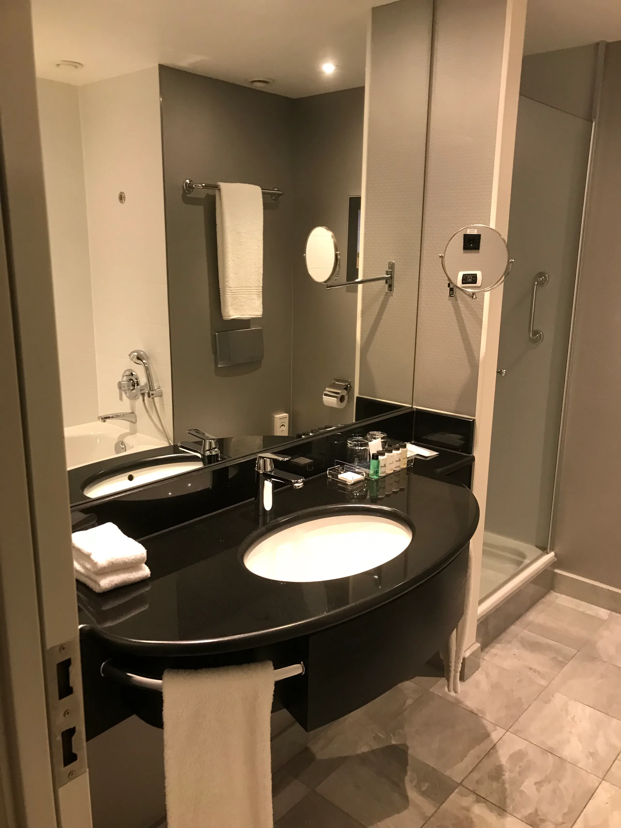 Moderne Hotelbad mit schwarzer Arbeitsplatte und Dusche