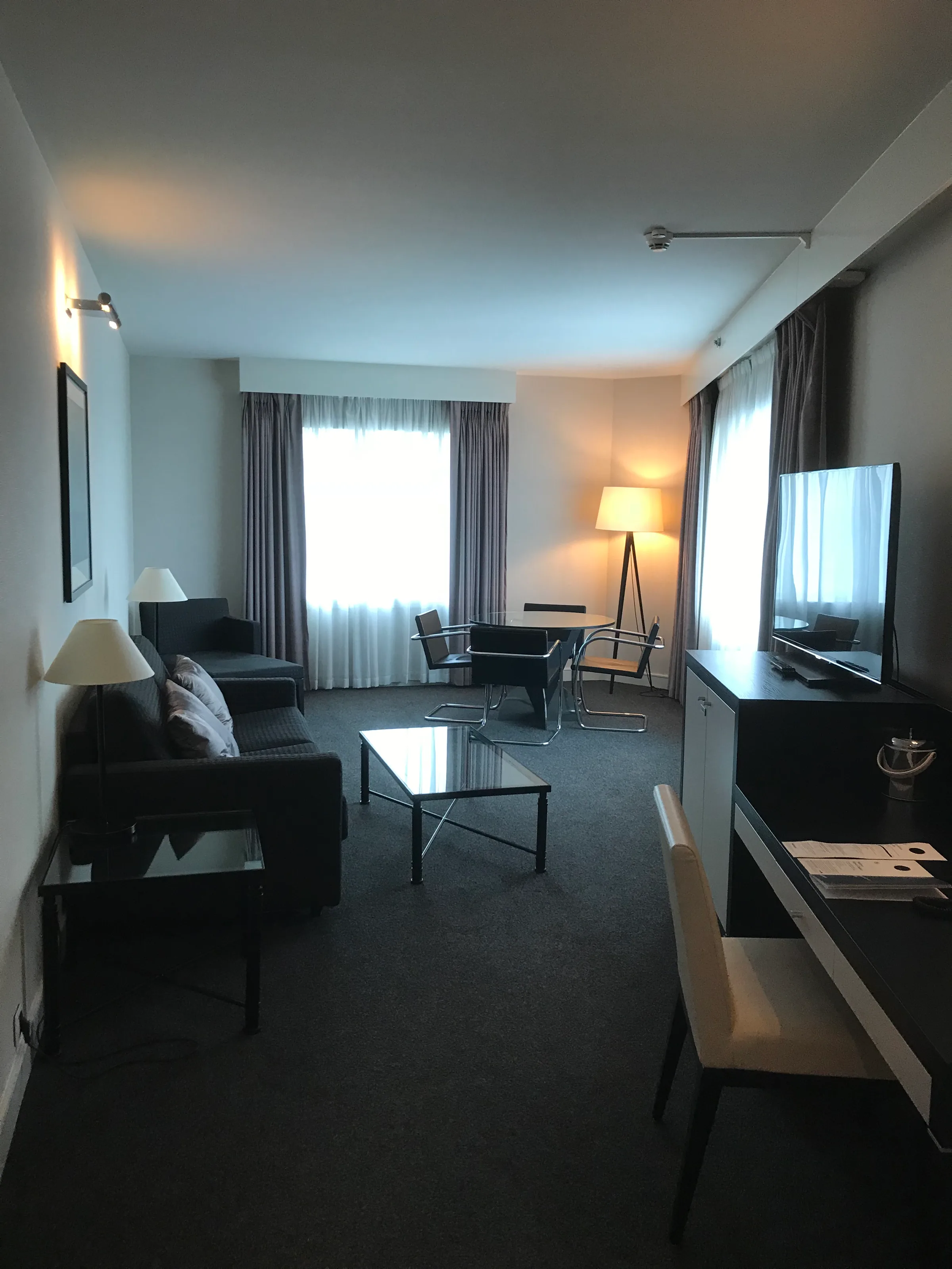 Hotelzimmer mit Couch, Sessel und Fernseher