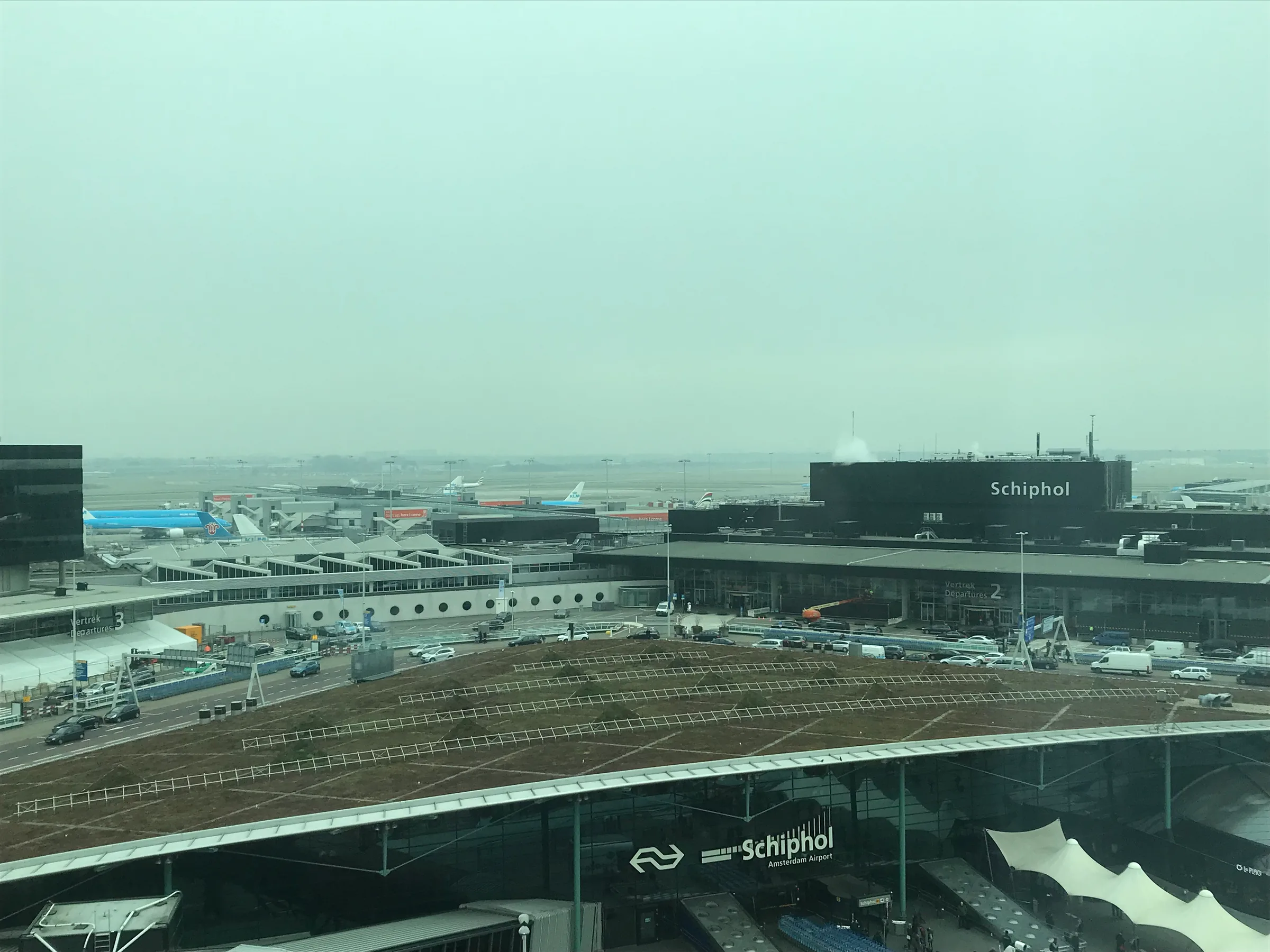 Flughafen Schiphol mit vielen Flugzeugen und Passagierterminals