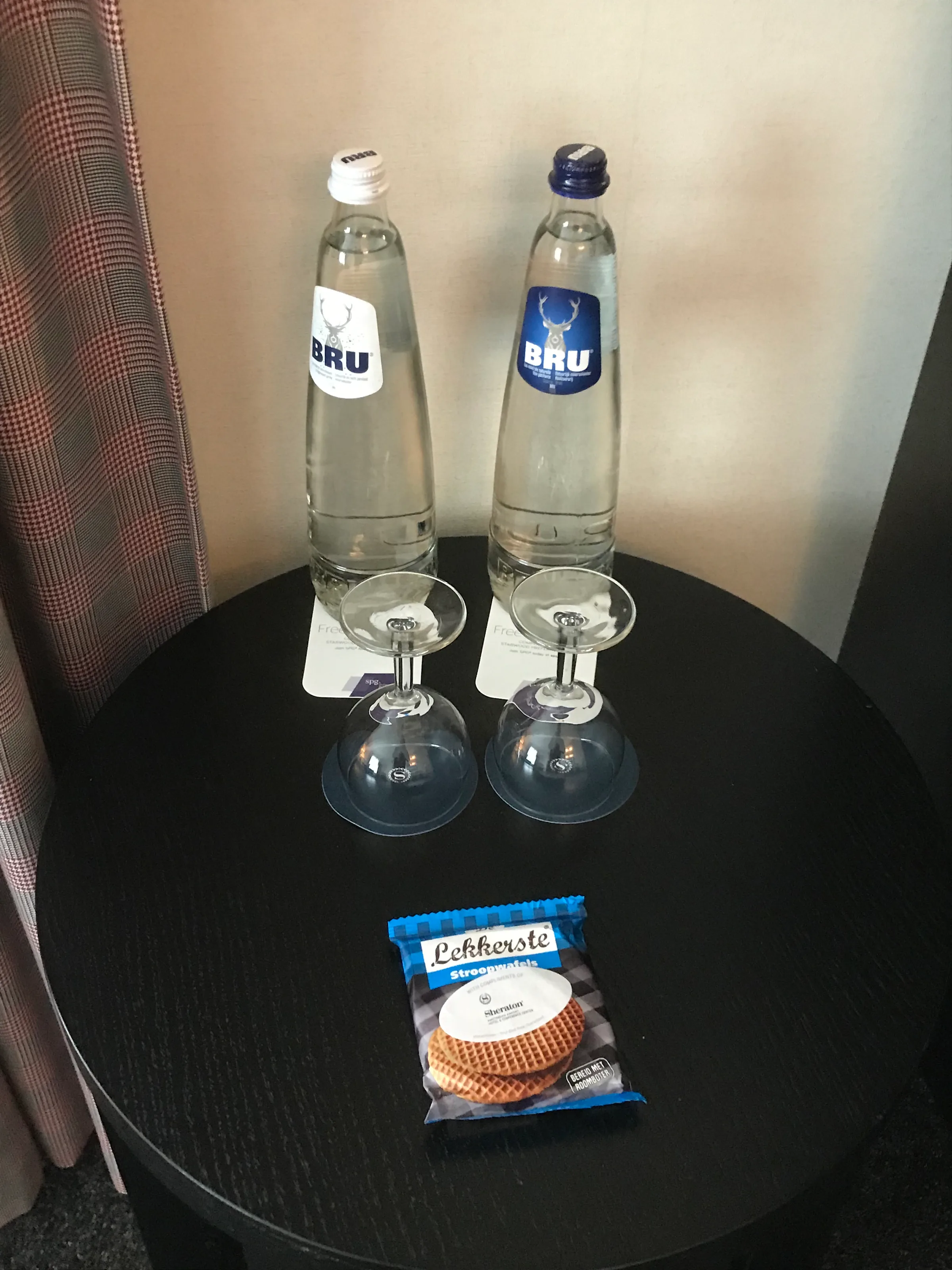 Hotelzimmertisch mit Mineralwasserflaschen und Waffelverpackung