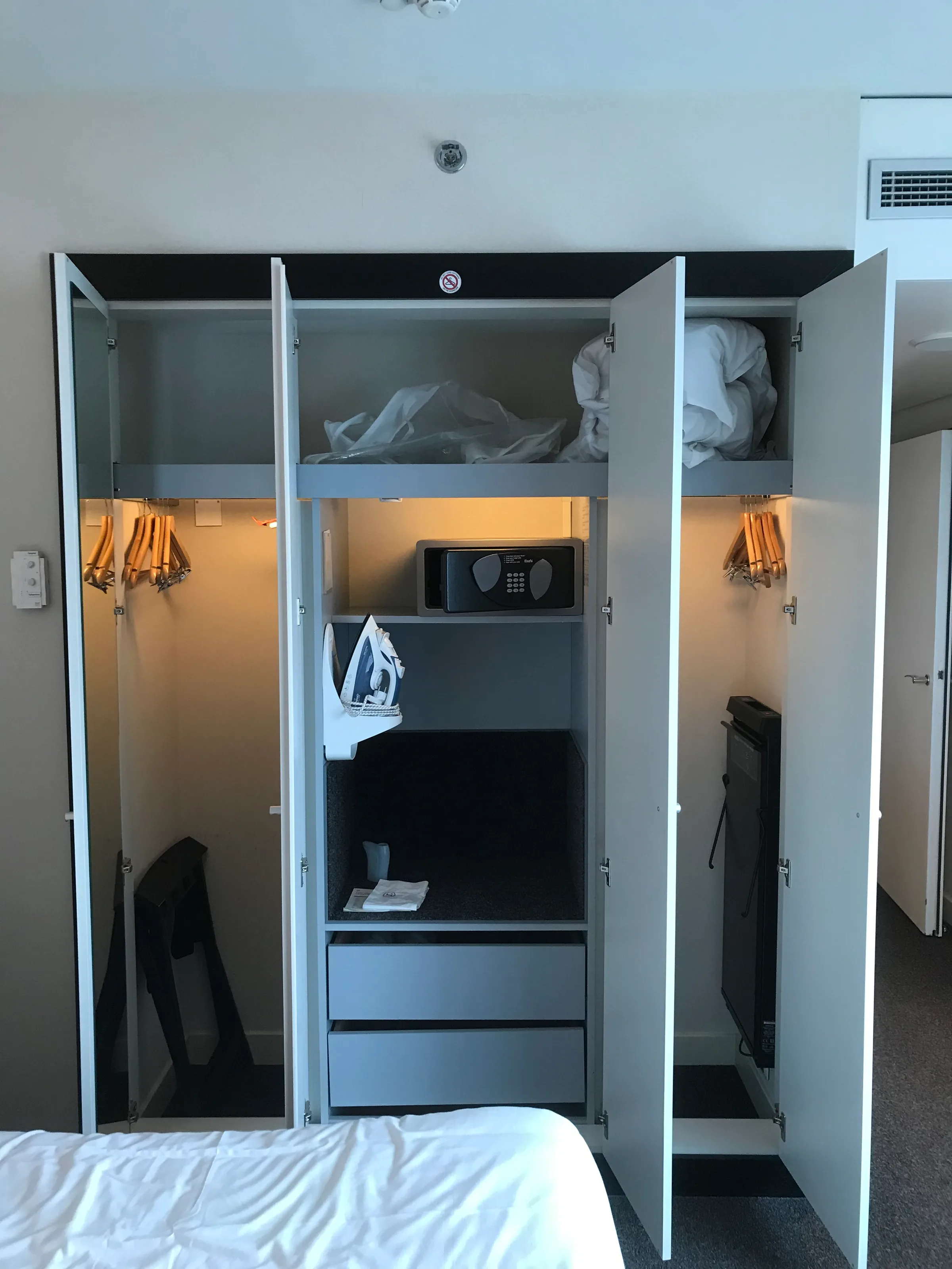 Gepflegtes Hotelzimmer mit offenem Schrank und Kleidungsständer