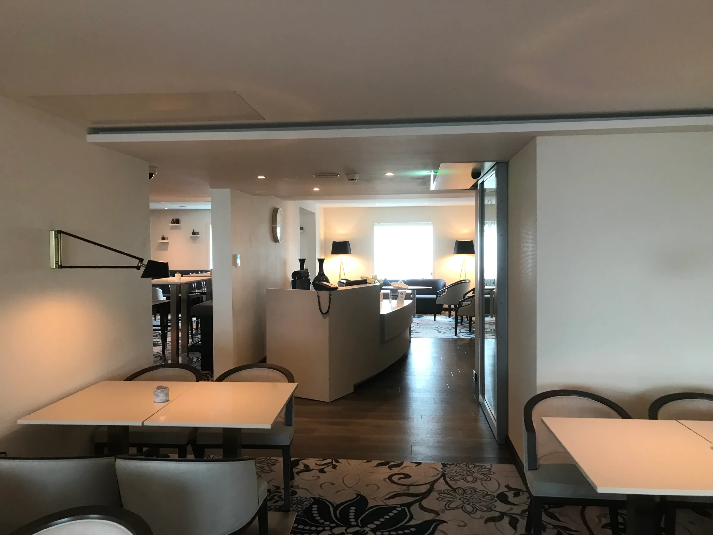 Hotellobby mit Tischen und Stühlen in neutralen Farben