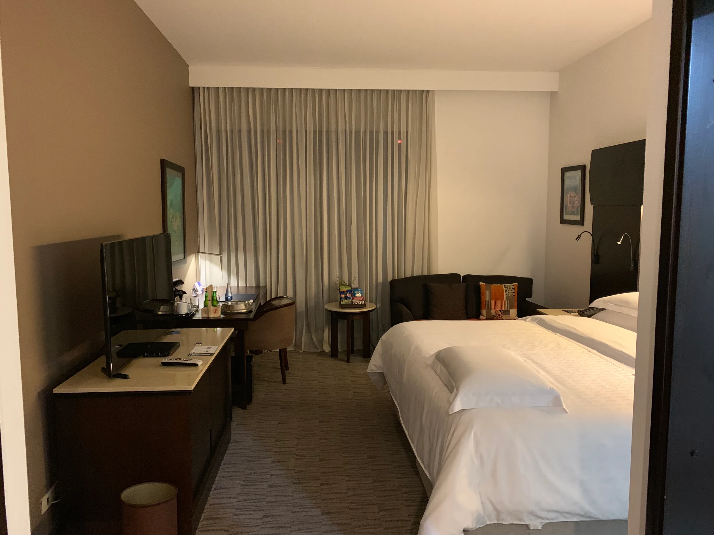 Hotelzimmer mit Doppelbett und Schreibtisch in neutralen Farben