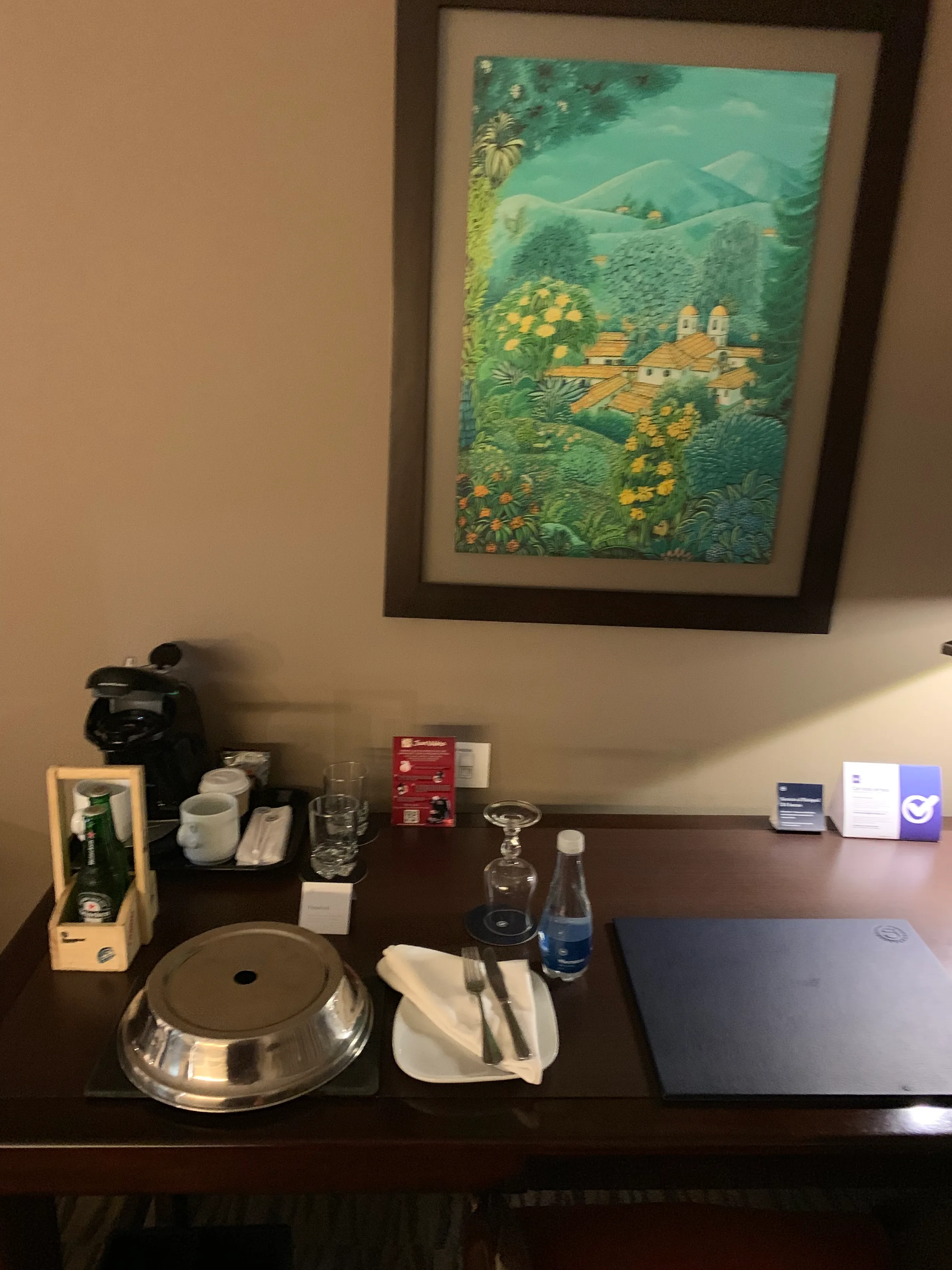 Hotelzimmer mit Kaffeevollautomat, Getränken und Gemälde an der Wand