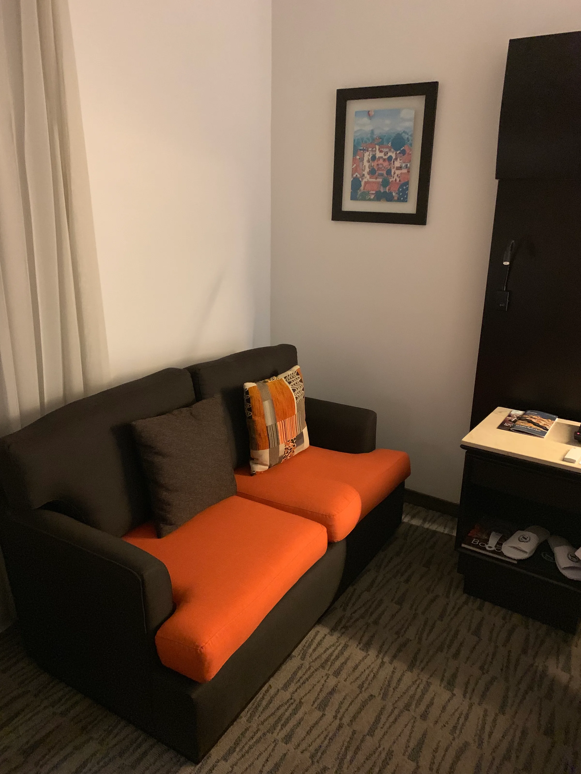 Hotelsofa mit orangefarbenen Polstern und Kissen