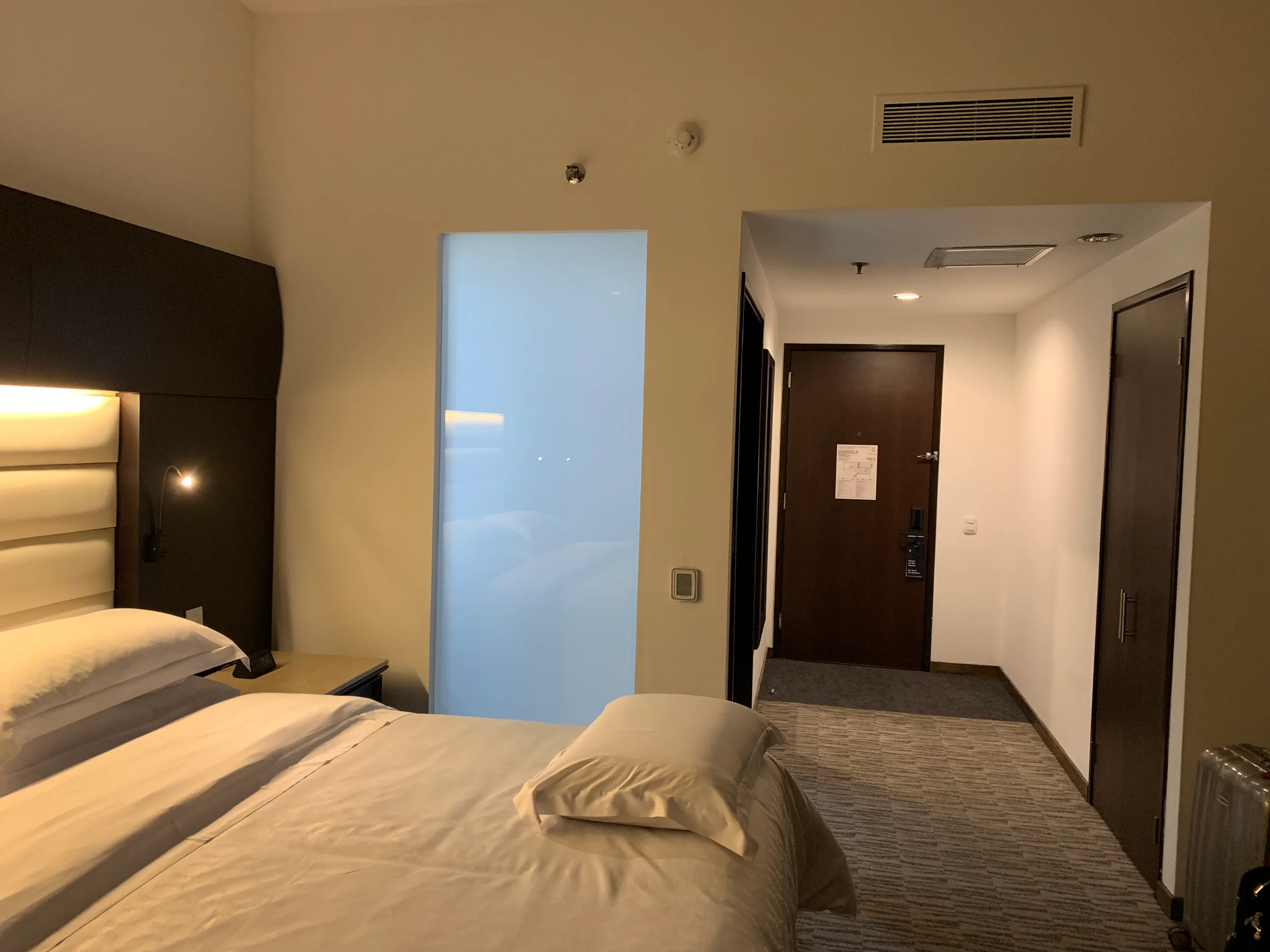 Hotelzimmer mit Doppelbett und Tagesdecke in Grautönen
