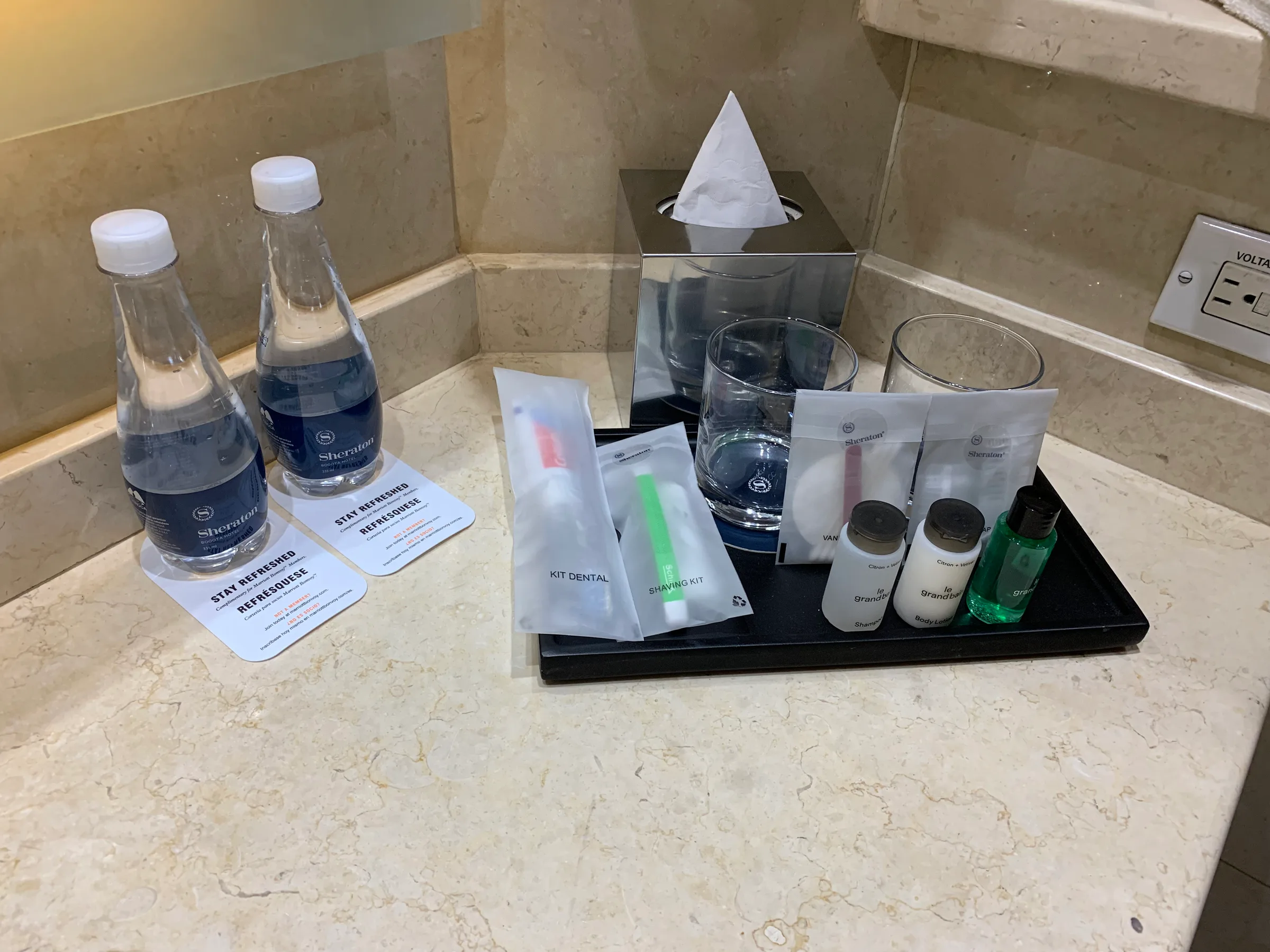 Hotelzimmerecke mit Mineralwasserflaschen und Zahnpflegeset