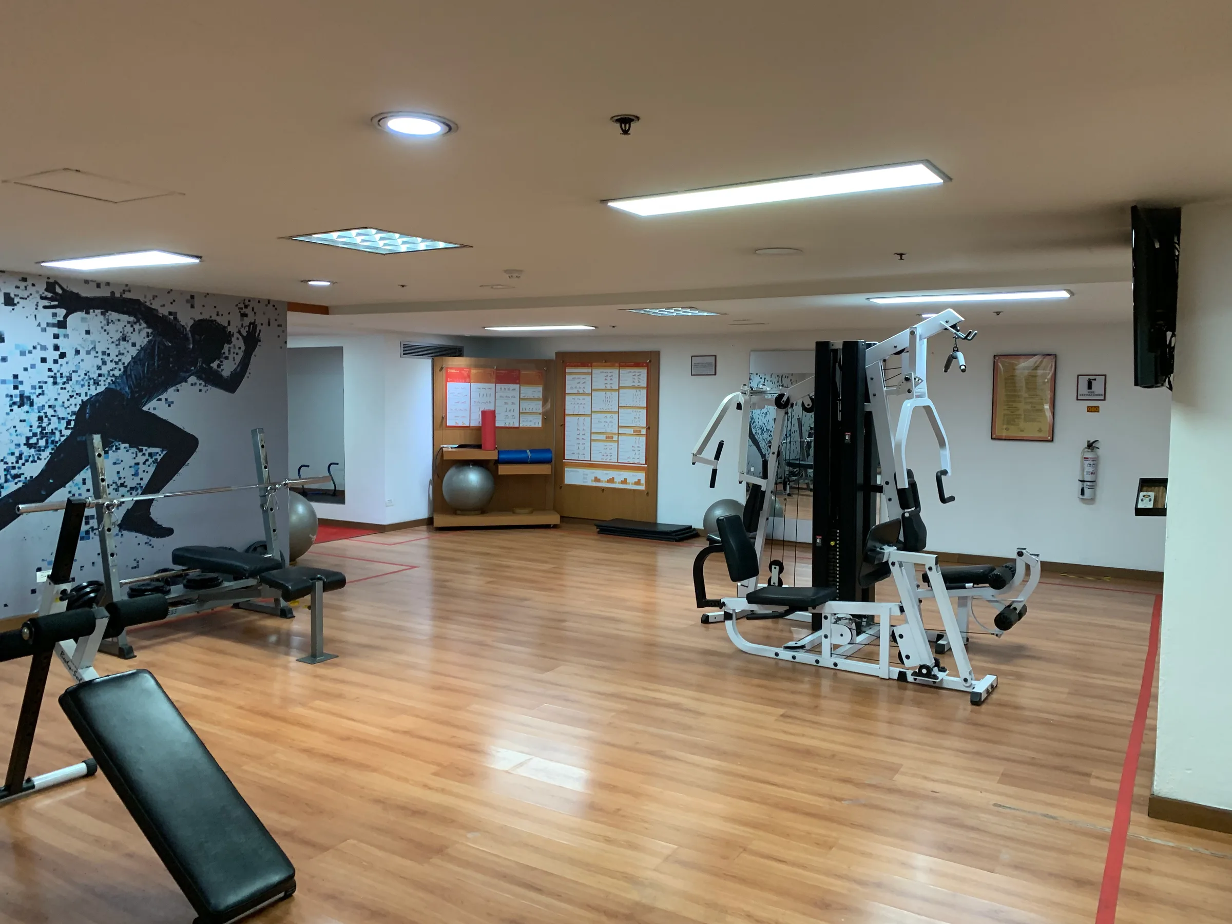 Fitnessraum mit Trainingsgeräten und Wanddekoration