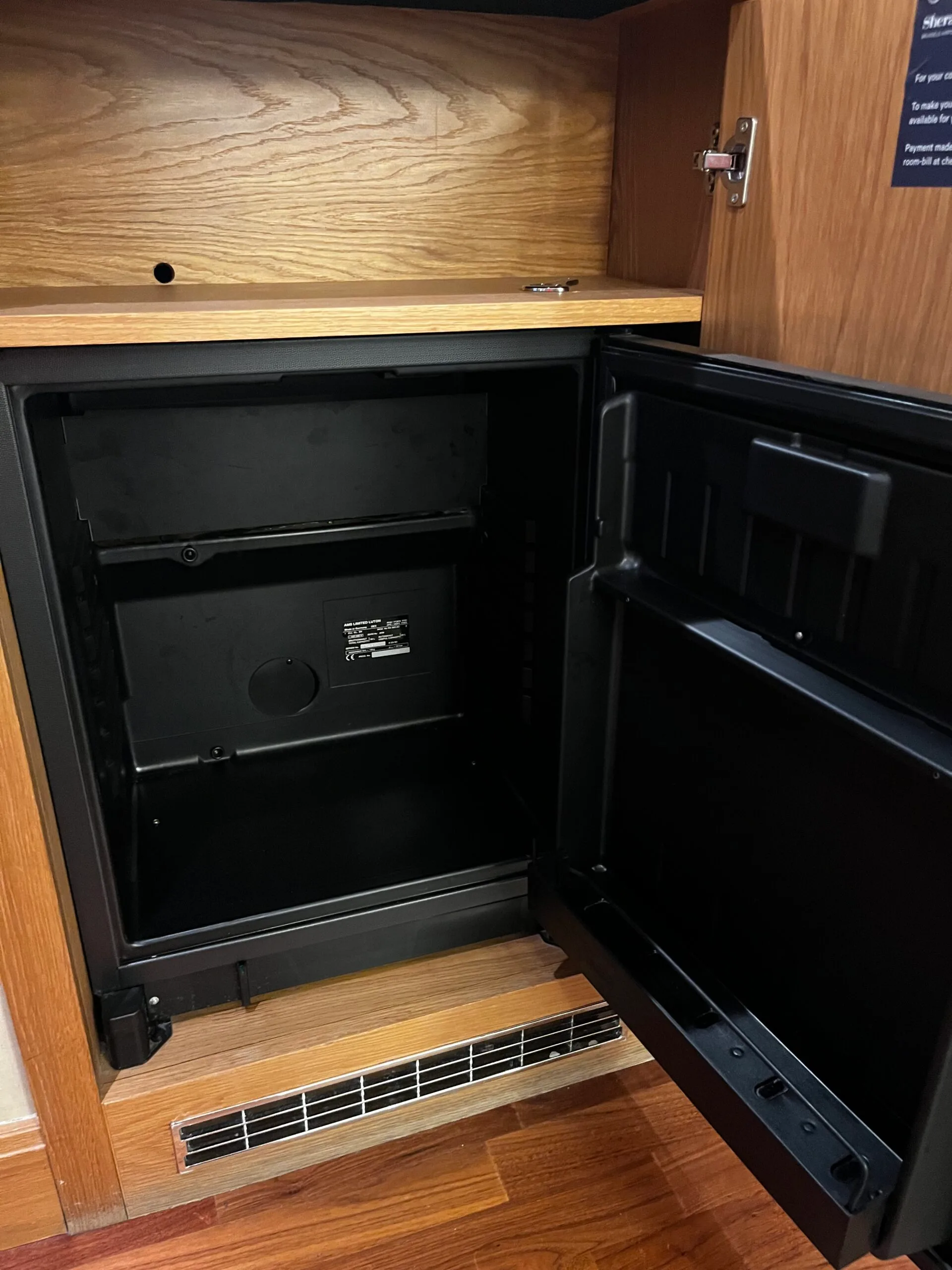 Hotelkühlschrank mit offener Tür und Holzverkleidung
