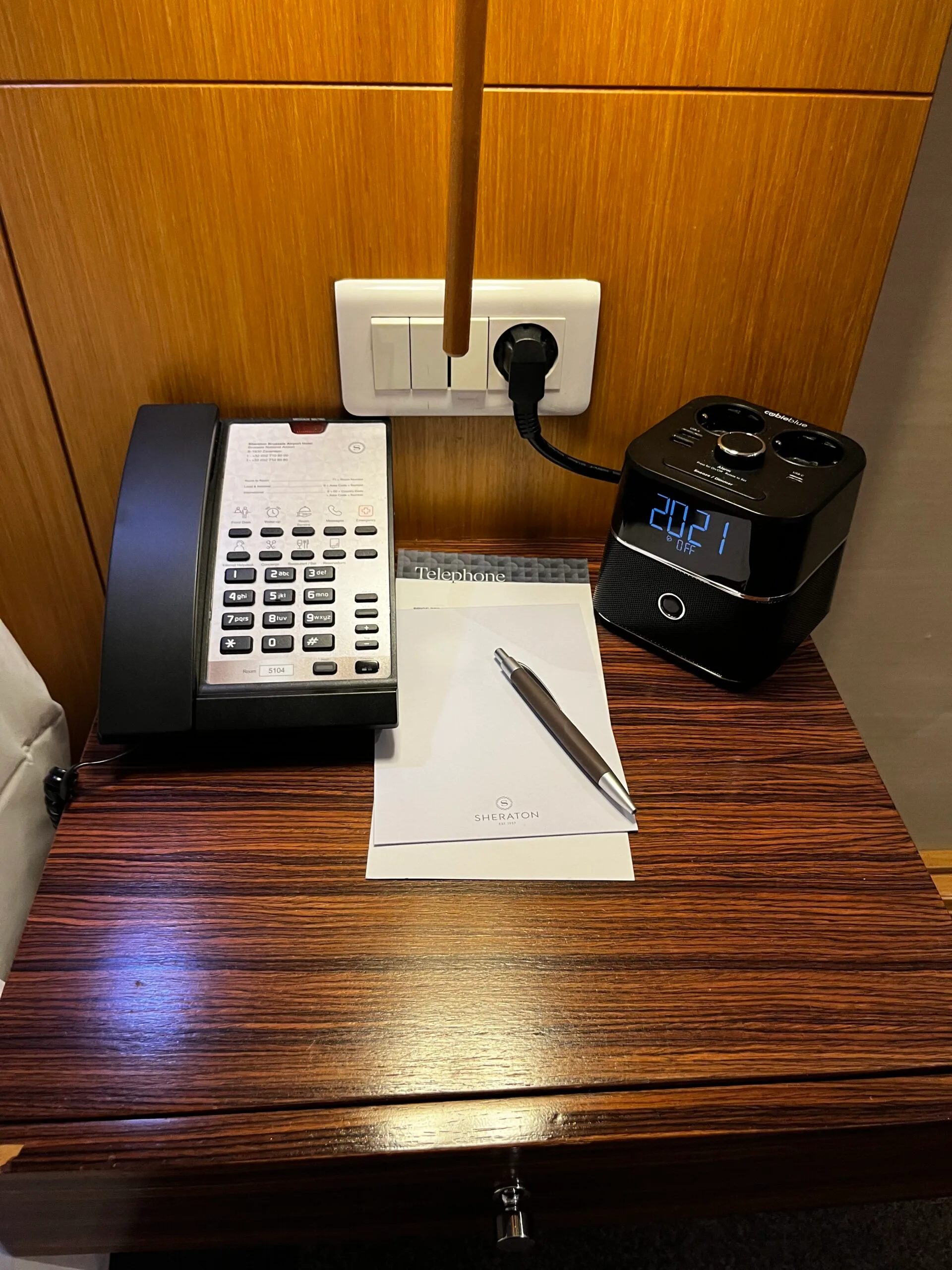 Hotelnachttisch mit Telefon, Uhr und Stift