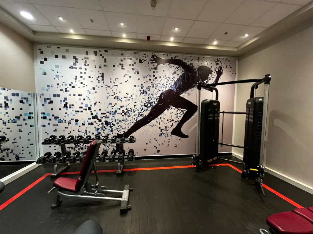 Fitnessraum mit Wanddekoration und Trainingsgeräten