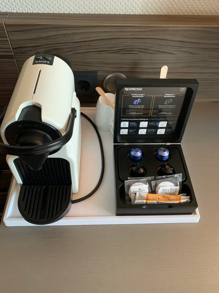 Hotelzimmer mit grünem Sessel und dekorativem Couchtisch