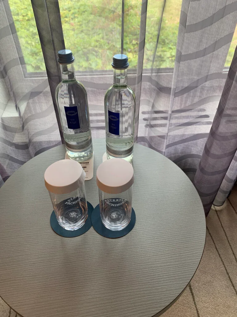 Zwei Flaschen Wasser auf einem Tisch mit zwei Gläsern darauf