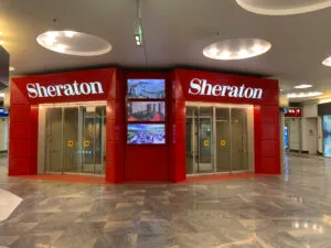 Sheraton-Hotellobby mit roten Wänden und digitalen Bildschirmen