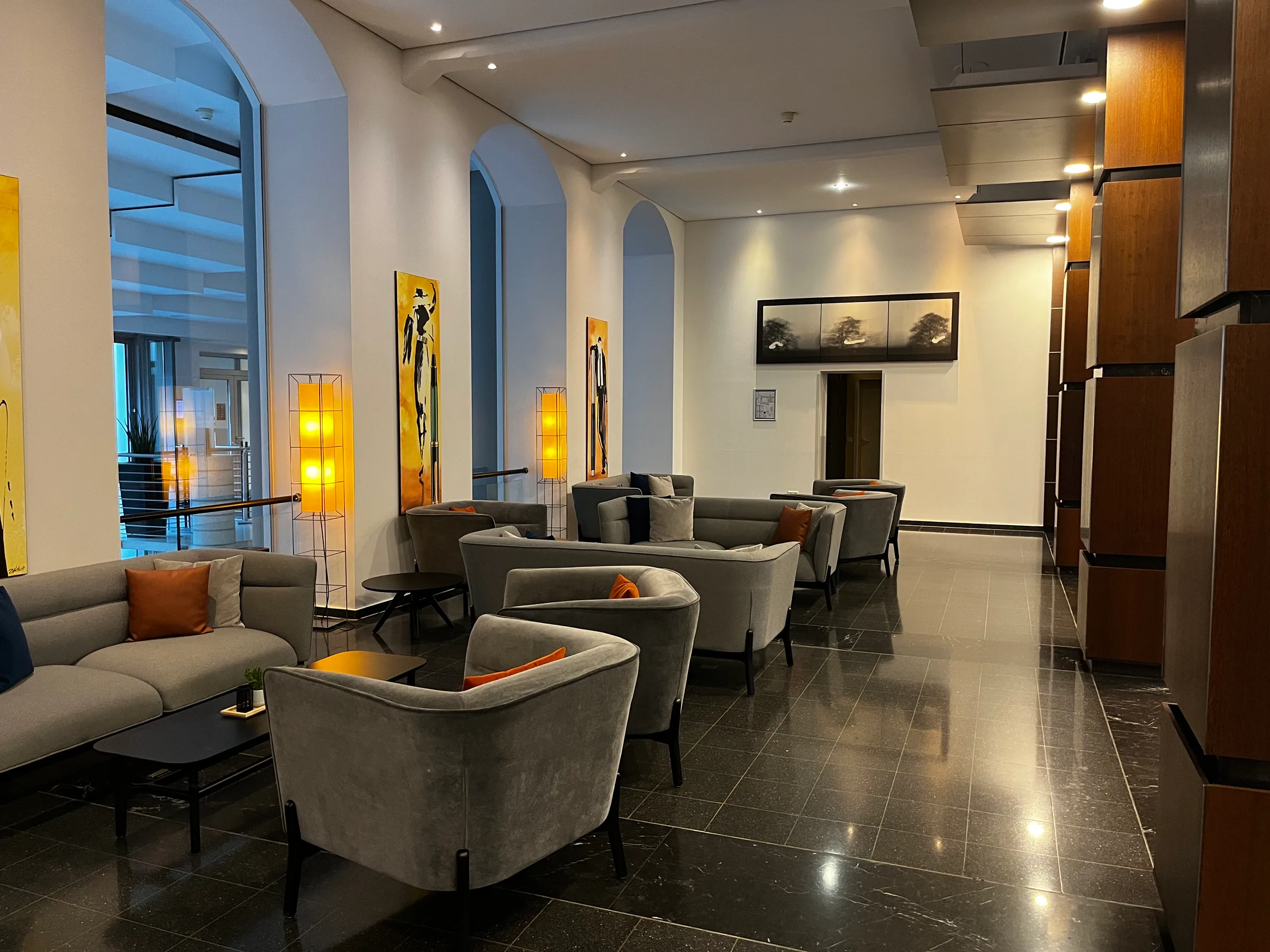 Loungebereich im Sheraton Hannover Pelikan Hotel mit Sesseln und Gemälden an der Wand
