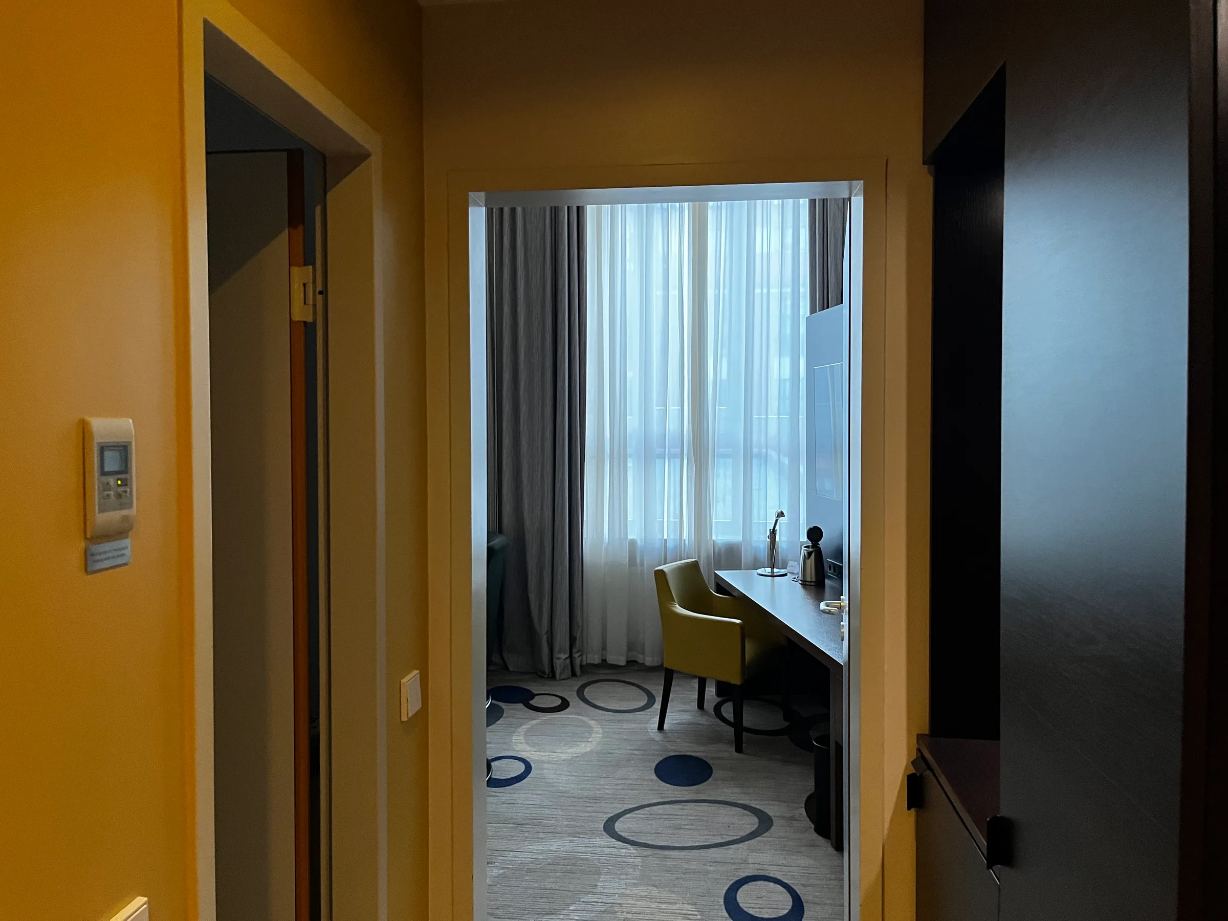 Hotelzimmer mit Schreibtisch und Stuhl vor Fenster