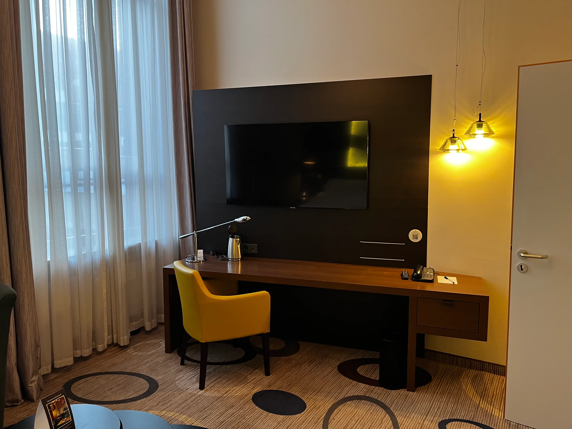 Hotelzimmer mit Schreibtisch und Flachbildfernseher