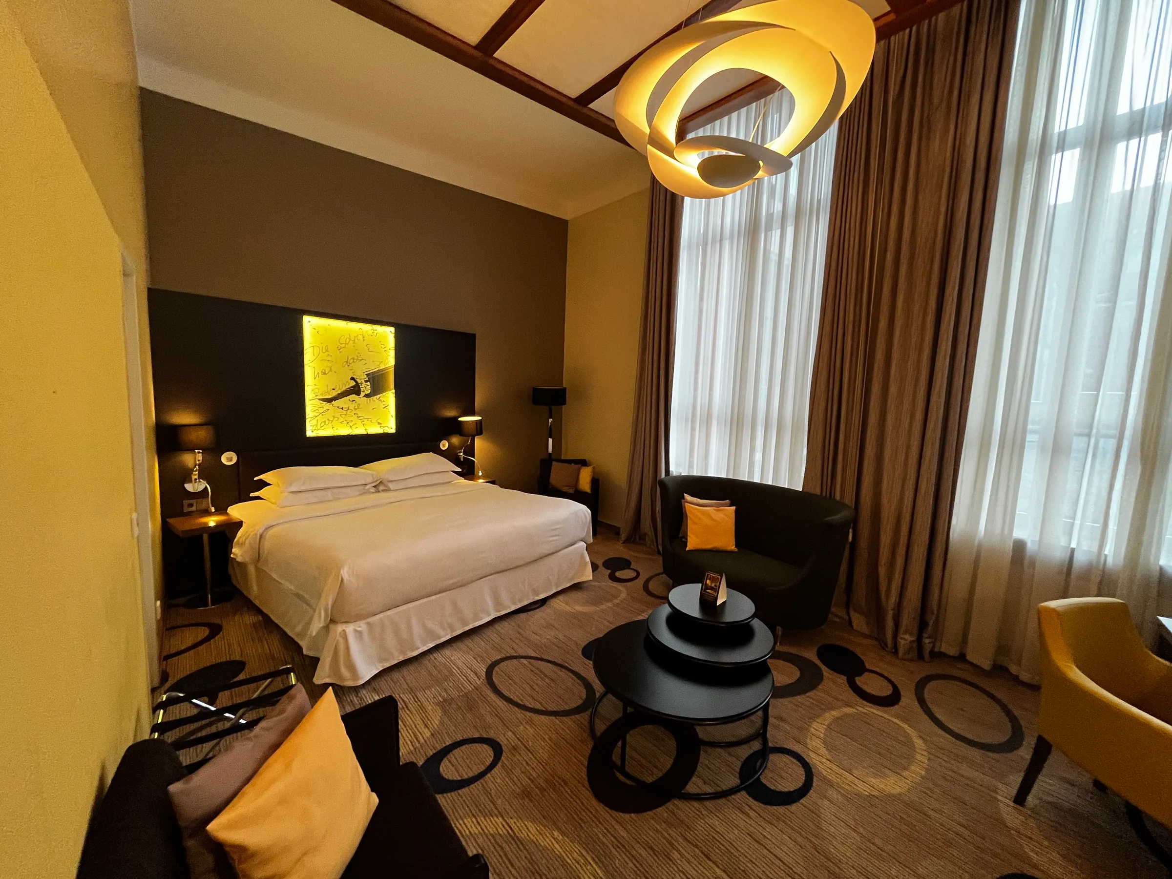 Hotelzimmer mit Doppelbett und moderner Einrichtung in Grautönen