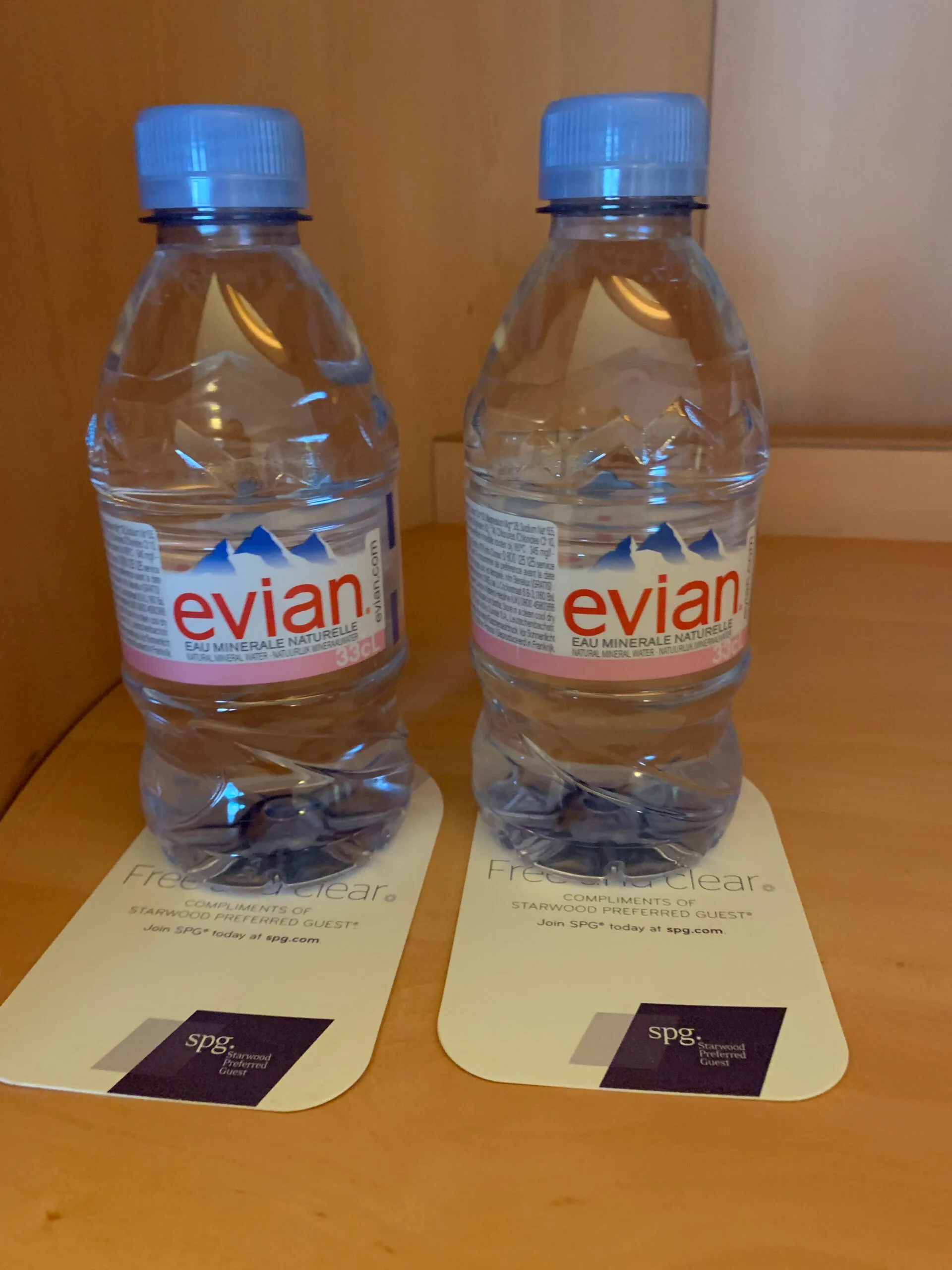 Zwei Flaschen Evian-Wasser auf einem Tisch