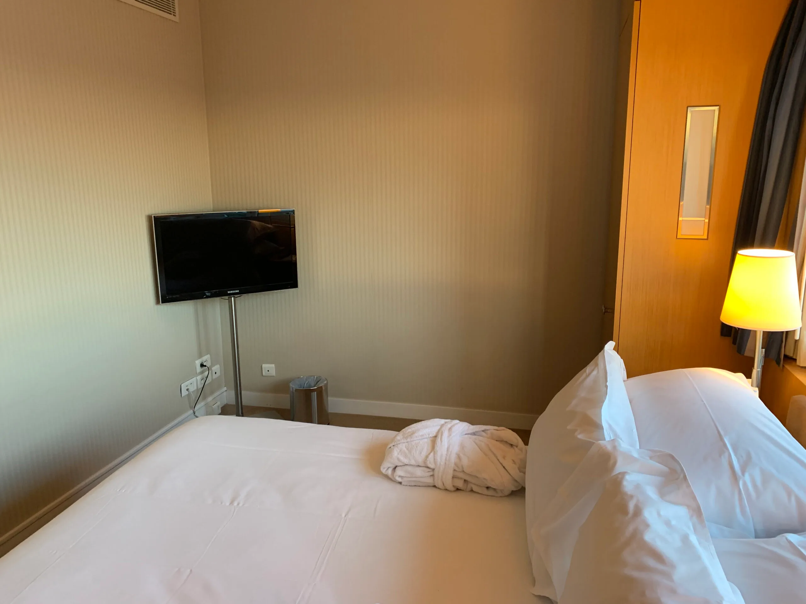 Hotelzimmer mit Doppelbett und Fernseher an der Wand