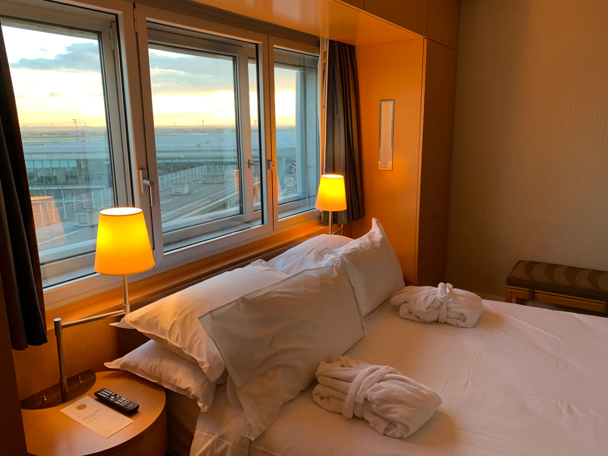Hotelzimmer mit Doppelbett und Tagesdecke bei Sonnenuntergang