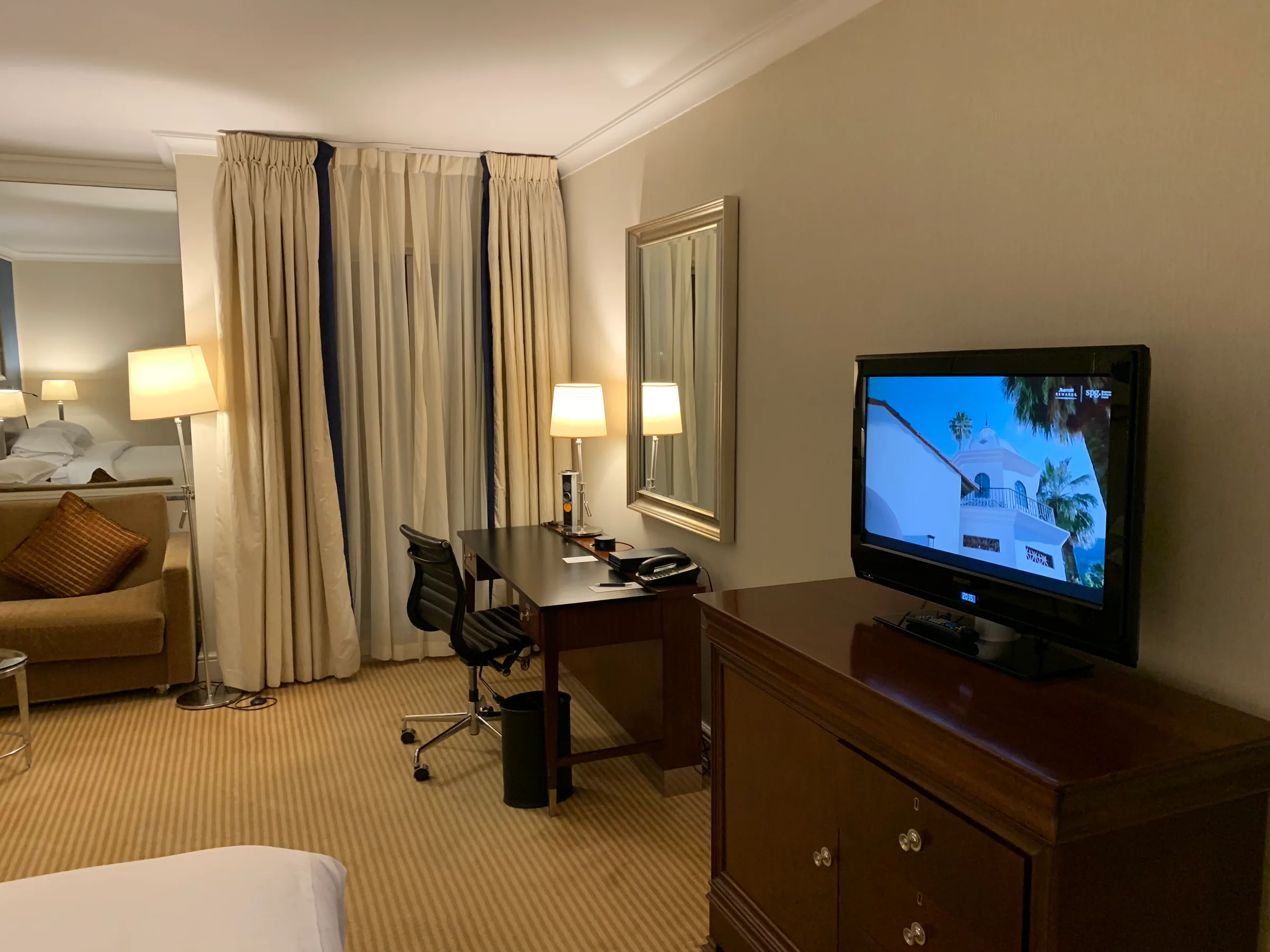 Hotelzimmer mit Schreibtisch, Fernseher und Doppelbett