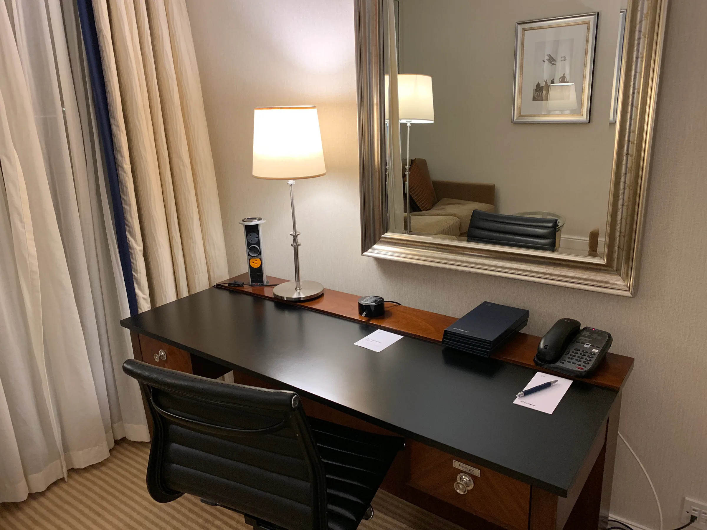 Hotelzimmer mit Schreibtisch, Telefon und Spiegel