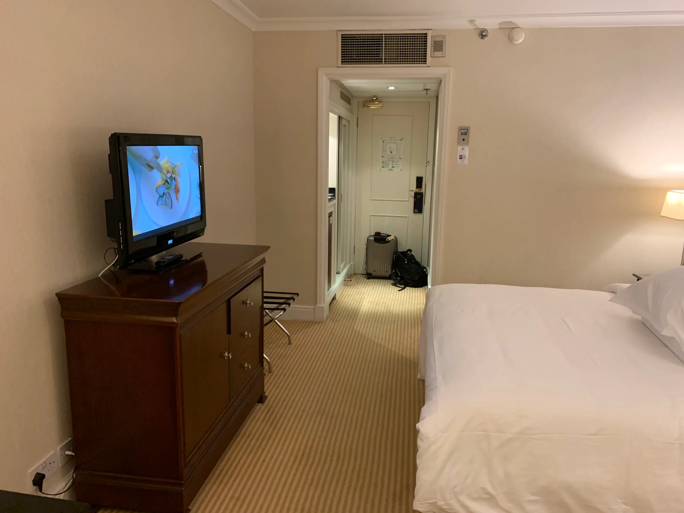 Hotelzimmer mit Doppelbett und Fernseher auf Kommode