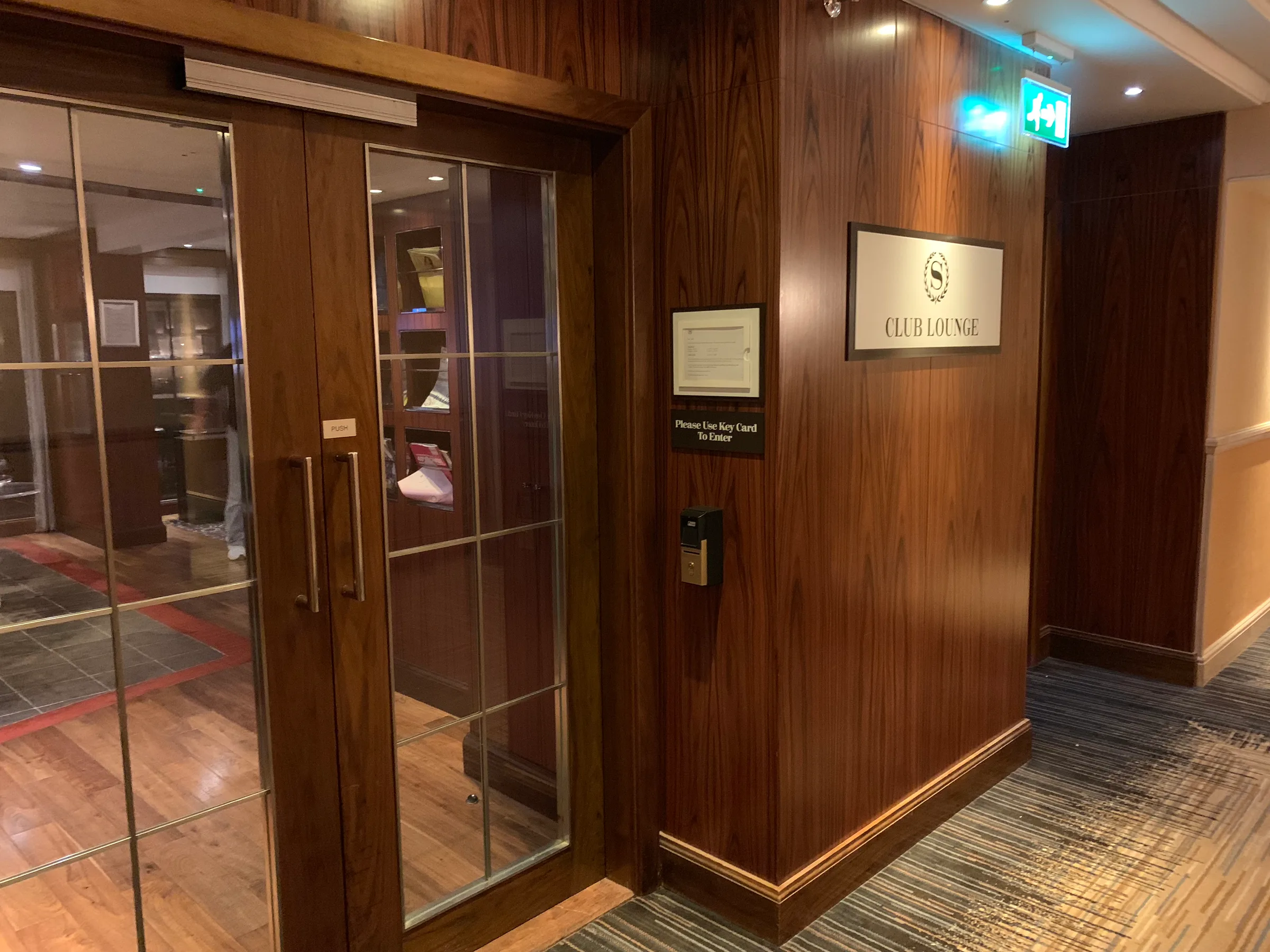 Eingang zum Club Lounge mit Holzverkleidung und Schild