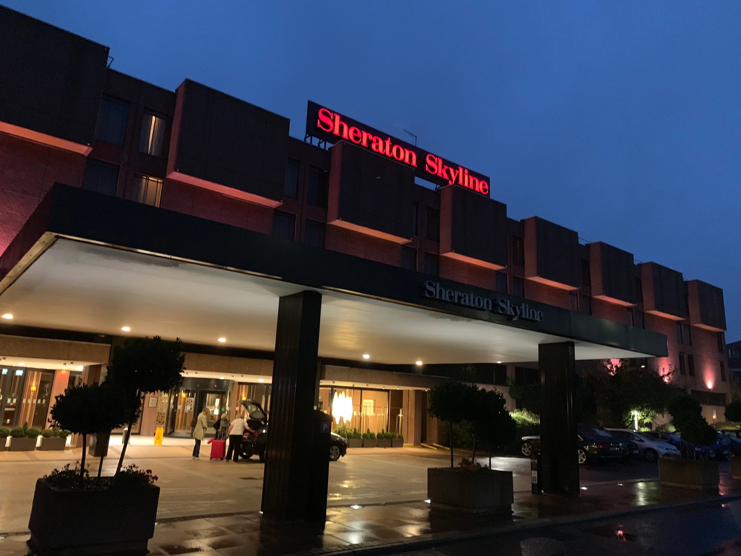 Eingangsbereich des Sheraton Skyline Hotels bei Dämmerung